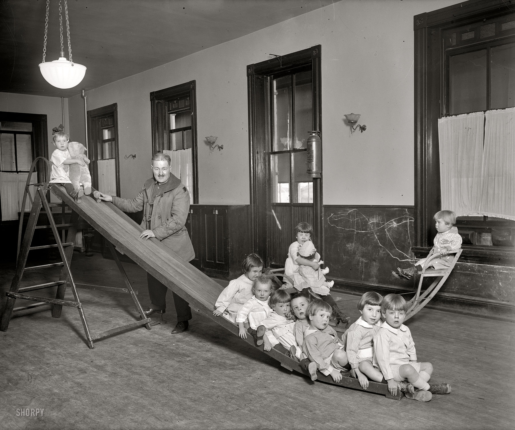 Washington, D.C., circa 1921. "Foundling Hospital, playroom." Tots at the Washington Asylum for Foundlings, 1715 15th Street N.W., with their benefactor Lt. George Pickett 3rd. Harris & Ewing Collection glass negative. View full size.