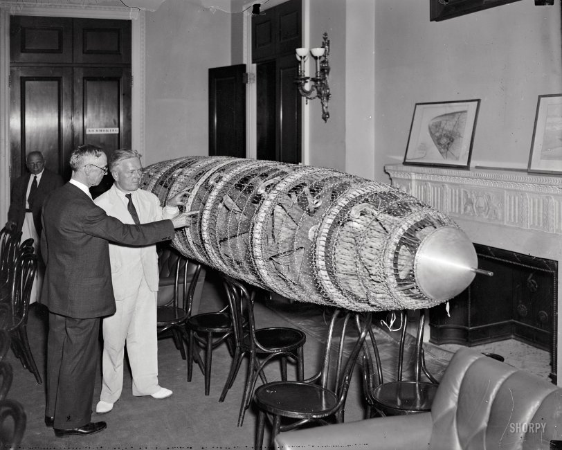 June 9, 1937. "Congress sees model of new proposed American-designed dirigible. Rep. Edward A. Kenney (right) of New Jersey, Chairman of the House Interstate Commerce Committee, viewing a model of a new American designed dirigible displayed at the Capitol today. Roland B. Respess, President of the Respess Aeronautical Engineering Corp., is pointing out the features of the ship to the House member. The House Interstate Subcommittee is hearing the witness on a bill recently introduced to authorize the loan of $12 million for constructing two eight-million-cubic-foot dirigible airships, a large American airship plane, and Atlantic operating terminal with a view toward establishing twice-a-week Trans-Atlantic airship service." Harris &amp; Ewing glass negative. View full size.
