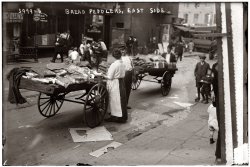Bread peddlers, East Side Manhattan circa 1915. View full size. 5x7 glass negative. George Grantham Bain Collection.
Fresh breadImagine trying to sell bread like this today, I think the board of health would be shocked
Solarize/preflashThe out of focus images of a few people in the background look almost solarized.  Can anyone explain this effect.  Could it be an artifact of pre-flashing the film?
Re: Solarize / preflashThe solarized-looking areas are places where the thickest parts of the emulsion are deteriorating, getting darker and flaking on the glass negative, possibly due to mold. On the positive when the image is inverted, the effect is a white outline. There was no flash used. And no film, either.

Ah! that explains it.Thanks.  The mystery is solved.
BTW
"Pre-flash" was an old technique of slightly fogging the film in an attempt to soften the image.  It predates flash photography.
Secret Agent ManI love the guy peeking around the corner!!
[Also note the kid on roller skates! - Dave]
(G.G. Bain)