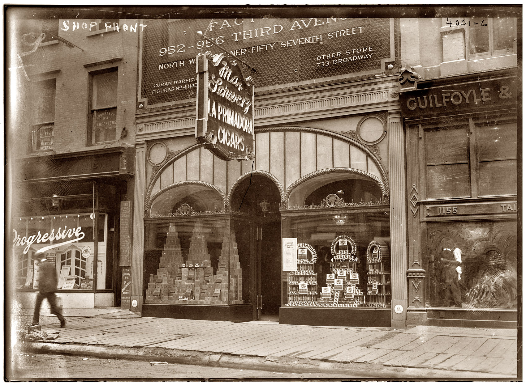 Another view of the Primadora cigar shop, with a lunchroom, furrier, carpenter and men's clothier as neighbors. View full size. Geo. Grantham Bain Collection.