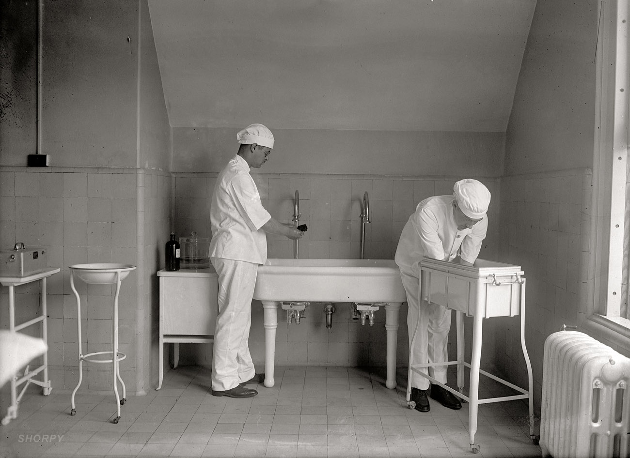 1922. "Surgery #9." One last peek inside the OR before moving on to other things. Next week we'll return. National Photo Company glass negative. View full size.