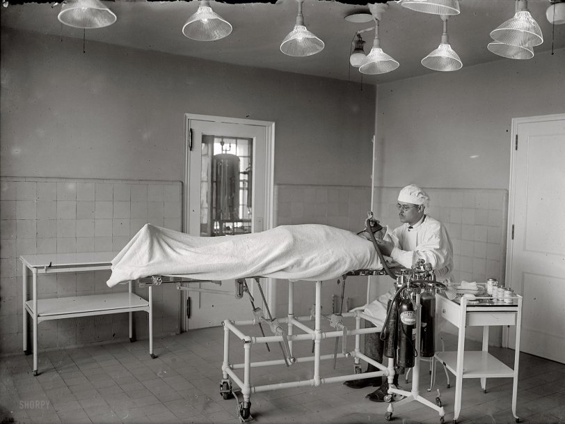 1922. "Surgery #12." Another selection from the "surgery" series of images, this one showing an anesthesiologist administering nitrous oxide prior to the operation. National Photo Company Collection glass negative. View full size.
