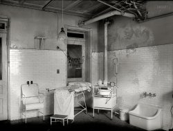 Washington, D.C., 1922. "Social Hygiene exhibit. House of Detention, Women's Bureau. Clinic -- Mental and medical examinations are essential in order to make intelligent disposition of cases." National Photo glass negative. View full size.
Can&#039;t help it; house of horrors!I am sure this was typical for the time period, but I think it would make a GREAT set for a  horror movie. Even the stirrups have a sinister appearance. Yikes, where's the garlic and the holy water?
I hope those spotsare on the picture, and not the sheets!
CreepshowLooks like something out of a horror movie.
Even NowI'm gonna guess that the great majority of inmates did not have even basic health care outside the Jailhouse. At least the Department of Corrections Doctor was a step in the right direction. Amazing that to this day some prisoners are getting better care than their families on the outside.
Imaginewhat went on in this room -- note the stirrups on the table; the stethoscope on the table; the lidded disposal can. Medical examinations (of the women in detention) were "essential in order to make intelligent disposition of cases." That is, did they have a social disease and/or were they pregnant. One wonders what the "disposition" might have been.  
Eugenics and StirrupsInvoluntary sterilizations and abortions were once legally sanctioned means to toward the "intelligent disposition of cases."  Considering that the Social Hygiene movement quite openly included the elimination of "racial degeneration" and "genetic defectives" among its progressive aims, there were probably quite a few unsavory operations carried out in this room.  
Wonder if there were drains in the floor?
One for Ghost Hunters?If this photo were taken out of context, and the staining was not seen as affecting the photo itself, this could be a candidate for ghostly spirit heads imprinted on the wall looking at their possible point of departure from this mortal coil.
(The Gallery, D.C., Medicine, Natl Photo)