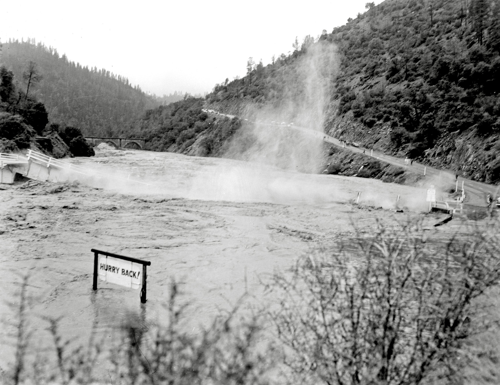 The California Highway 49 steel bridge river crossing could only withstand so much and finally succumbed to the water surge from the failure of Hell Hole Reservoir in December 1964. Norm Sayler Collection, Donner Summit Historical Society. View full size.