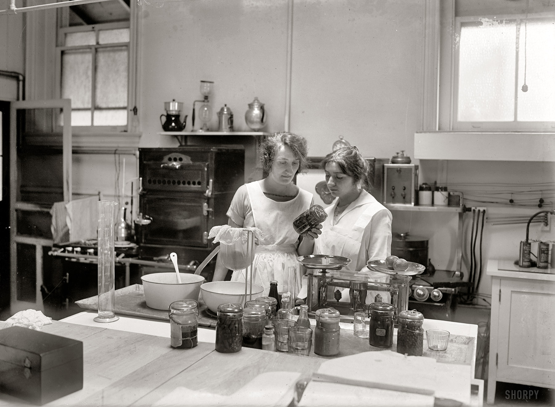 "Two women in kitchen. May 8, 1923." Not just any old kitchen, this is the laboratory where Odessa Dow conducted her ground-breaking baking research. National Photo Company Collection glass negative. View full size.