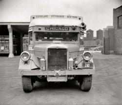 Washington, D.C., circa 1938. "Greyhound bus." This coach looks like it knows its way around. Harris &amp; Ewing Collection glass negative. View full size.
Where&#039;s Clark Gable?This looks like the bus in "It Happened One Night." Anyone for a rousing chorus of "The Man on the Flying Trapeze?"
BaldyTwo front tires are ready to be changed!
Deja ViewIsn't this the bus from "It Happened One Night"?
Fageol Safety CoachBuilt by the Fageol Truck and Coach Company of Oakland, CA, the Fageol Safety Coach was introduced in 1922 and was so named because of its low center of gravity and equal-length front and rear axles. Fageol was the first firm to build a bus from the ground up. By the 1930s, most Greyhound buses were Fageol Safety Coaches. The night bus taken by Clark Gable and Myrna Loy Claudette Colbert in "It Happened One Night" (1934) was an Atlantic Greyhound Safety Coach, its crowded interior seen here in the dimly-lit singalong scene. Fageol was bought out by Peterbilt in 1939.

[The bus in our photo has a General Motors Truck Corporation radiator badge with the Yellow Coach emblem. - Dave]

Have the mechanics look her over.Tires? Love the blinker system. What are those two jugs on the front? Some kind of oil filled shock absorbers?
Wrong Way BusWhoops! General Motors Yellow Bus? Couldn't read the logo in the resolution available on my laptop. When I Google-Images-searched using the string "'It Happened One Night' bus" this image came up, identified on its host website (the Internet Movie Cars Database) as a Fageol Safety Coach. Guess they couldn't read the GM plaque on the radiator in their photo either. Here is an exterior shot of the Gable-Loy Atlantic Greyhound bus with its many 1933 state license plates. Since it looks quite like the Shorpy bus, it must not be a Fageol.

ShockingThe jug things are oil-chamber shock absorbers.

No LoyThat's Claudette Colbert, not Myrna Loy, on the bus.
YikesSeems like it could get through traffic through sheer intimidation.
Definitely intimidatingWhen I first looked at this picture I immediately assumed that it was a military vehicle, maybe an armored personnel carrier. Would hate to look in my rearview mirror and see this crowding me.
CrankyIs that a hole for a starter crank?
Bus-FaceMy sister recently told me that cars have faces or expressions. If it was ever true, it would be for this bus, which appears to have a permanent scowl.
[And bugs in his teeth. - Dave]
Yellow Coach or Fageol?  There are a number of pictures of Fageol Safety Coaches on this page:
http://www.hankstruckpictures.com/fageol.htm
All of the Fageol trucks and coaches have a distinctive logo that extends across the top of the radiator and is quite dissimilar to the GM logo.  
However, a bit more research shows that there are a number of diecast models of "Fageol Safety Coach - Yellow Cab" buses around in the antique toy market, and demonstrate the confusion in names which exists about the buses built in the 1920's and 1930's
This PDF file from busmag.com:
http://www.busmag.com/PDF/Greyh1.pdf
describes what maybe be a more definitive history of the Greyhound buses and may answer our question:
Fageol buses were indeed a great part of the Greyhound Fleet in the 1920's, but Greyhound developed an interest in Yellow Coach which expanded into bus manufacture and a custom model for Greyhound in the 1930's. Yellow Coach was eventually bought by General Motors.
The bus in our picture appears to be one of the custom Yellow Coach buses manufactured for Greyhound after the General Motors purchase of Yellow Coach.
Industrial strength mass transportationLooks like something one would have seen in the old Soviet Union. Signs on top should read Moscow-Leningrad-Stalingrad. Da, tovarich?
License plateIt reads "Maryland EX 3-31-39". Was that the expiration date of the plate? (valid until that date...) Or was it the licensing date? If it's the latter case, the photo had to be taken after March 1939.
[EX is an abbreviation for "expires." - Dave]
1938 Greyhound depotDoes anyone know where this might have been taken?  The background doesn't look like the old depot location on New York Avenue (now incorporated into an office building).
ShockingThe front shock absorbers are actually air shocks, with the Sharader Schrader valve on the top. The oil port is for lubrication of the sliding piston inside the housing.
(The Gallery, Cars, Trucks, Buses, D.C., Harris + Ewing)