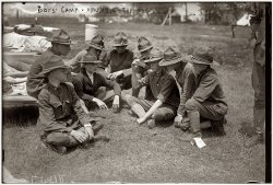 July 16, 1917. An exciting game of "mumble-the-peg" at scout camp outside New York City. George Grantham Bain Collection. View full size.
Mumbly-PegWe knew this as Mumbly-Peg. The trick is to get the pocket knife to land blade in-ground from different starting points, with different flips and fancy twists or even bouncing the handle end off a body part. My grandfather taught me this when I was about 7 or 8. My mother stopped it promptly. Just as well, I wasn't any good at it.
On the Nature of the MumbleAccording to the American Heritage dictionary:
From the phrase mumble the peg, from the fact that originally the loser had to pull up with the teeth a peg driven into the ground.
I suppose it doesn't really need to make sense.
Mumble, MumblyI used to play Mumbly-Peg as a child.  Never heard it called "Mumble the Peg."  Hadn't thought of that game in over 50 years. I'm trying to remember all the starting points.  If memory serves, you flipped the knife first from each finger tip, then progressed to wrist, elbow, shoulder, chin, nose, etc.  It got progressively more difficult.
Signet ringSeen the boy wearing a signet ring? Not that normal for a Boy Scout of his age I would think.
[I had one when I was a kid. Family heirloom from the 1860s. - Dave]
Mumblety-PegWe still played this unsafe game when I was a scout not more than 25 years ago.   Of course we had to do it away from camp, otherwise the Scoutmaster would take away the knife, take a corner off of your "totin' chip" and give the knife back to your father when you got home and tell him what you had been caught doing.
Me too!We used to play it as well being kids. I'm from Russia. Surely boys are not that much obsessed with "health and safety" even now. Thank you for all these great images of old time that bring a lot of memories and make me sad in some way... OK, not too much sad - I'm only forty.
Mumblety-pegWow, I also used to play that game as a Scout when I was a kid!  That picture just brought back so many memories.
Now that I am a Scoutmaster though I'm afraid there is no way I could allow my kids to play that game...  (I guess I'll just have to play with my fellow leaders away from the kids at the next camp!!!)
I love how their leader is probably looking at them play (leg of tall figure visible on the extreme right).
Pat
What were our parents thinking?"Jarts," Mumbly-Peg" ... Train tickets pinned onto children and a tip given to the porter to "watch" them ... Swimming in the river (or gravel pit) ... "Kick-the-can" at dusk on the city's streets ... Walking to school in the snow and rain.
It's a wonder any of us survived!
I'm just kidding of course, but our children seem to be "connected" (via TV, computers, etc) and time-programmed waay to much nowadays!
Funny, I never claimed I was "bored."  Probably because I knew that Mum or Dad would find chores for me to do!
Chevrons?I see one boy wearing what looks like the chevrons of a corporal, and another with those of a sergeant. Was this used as some sort of scout insignia at the time? I am unfamiliar with that.
(The Gallery, G.G. Bain, Kids, Sports)