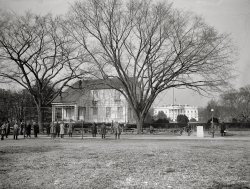February 2, 1924. "Home Sweet Home being moved to its permanent location, passing the south grounds of the White House. The building is to be used as a headquarters for the Girl Scouts of America." After eight months in Sherman Square the building, a "model American home" put up by the National Federation of Women's Clubs, was moved ("by hefty mules," said the Washington Post) to new digs at 18th Street and New York Avenue. The "snug little house" (weight 150 tons) was a replica of the Long Island residence of lyricist John Howard Payne, who 100 years earlier had written "Home Sweet Home." View full size.
WowWow, I didn't know they moved houses this way back then. My father (an architect) told me of how they moved entire buildings when he lived in LA back in the 60s, but I didn't imagined they had the machinery capable of doing this task back in the 1920s.
The FlagThe flag appears to be at half mast, but Woodrow Wilson didn't die until the next day. Curious.
[That's a rope over the tree branch. The flag is on top of the White House. - Dave]
(The Gallery, D.C., Natl Photo)