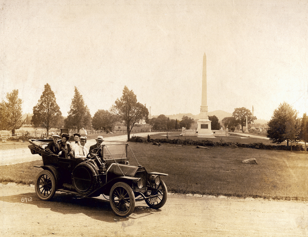 The photographers wagon can be seen in the distance on the left just above the heads of the people. The license plate on the car says Ohio 1910, but the location is the Gettysburg Battlefield. The obelisk is the monument to the United States Regulars. View full size.