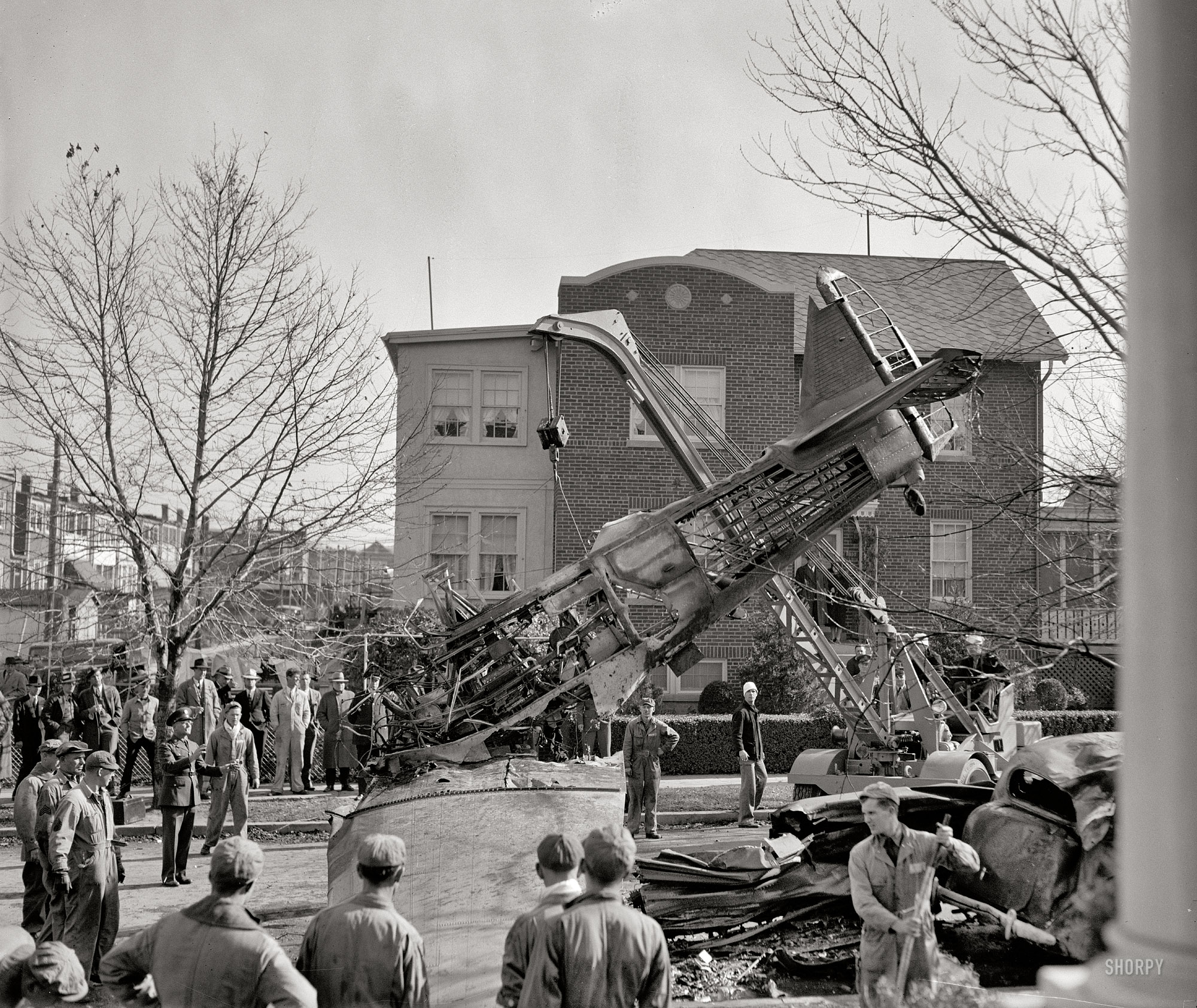 November 9, 1938. Washington, D.C. "Two U.S. Army fliers -- Lieut. Col. Leslie MacDill, General Staff Corps Officer, and Private Joseph G. Gloxner -- were burned to death today in the worst aerial tragedy in the history of the Capital when their plane crashed on a street in Anacostia, a short distance from Bolling Field. Three automobiles were wrecked in the crash. Col. MacDill was piloting the plane." Harris & Ewing Collection glass negative. View full size.