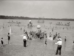 July 10, 1924. "Pushball at Tidal Basin." National Photo Co. View full size.
So many details!There are so many interesting details in these photos that it's always a treat examining them! For example, there's a shower right in the middle of the river, to the left of the image. Like someone pointed out in another picture, the swimming suits look like they were made of some sort of natural fiber (wool), since they do have a tendency to climb and stick when wet. And this jolly scene takes place in a makeshift playpen of sorts, made with what look like stakes in the shallow part of the river. How different of today's hectic world!
I'm curious; in the background you can see a building. Is it the Lincoln memorial?
GirlsIs it not ineffably sad that so few girls are part of the frolic?  One girl is separated from the fun, metaphorically enjoying the roughhousing joy--but from a distance.
I&#039;m pretty juvenileTo me, "Pushball at Tidal Basin" sounds like a euphemism, for, you know, something else. 
Sanctioned PushballNotice the two officials.  "OK, you hooligans.  Take it easy or someone might lose an eye."
Pushball reincarnatedPushball never quite caught on, but no one has commented that it was reincarnated, in a version that was both anarchistic and socially responsible, as Earthball. Of course, Earthball didn't catch on either.
The BackgroundI live quite near Washington DC.  That's absolutely the Lincoln Memorial in the background!
As viewed from?I'm guessing this is close to the site where construction began 15 years later on the Jefferson Memorial.
ShowerHow in the heck does that shower work? Must be some sort of foot pump to operate it...?
[They work the same way the shower in your house works. - Dave]
(The Gallery, D.C., Natl Photo, Sports, Swimming)