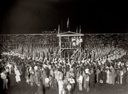 Sunday, August 9, 1925. "KKK services." The "services" at the Capital Horse Show grounds in Arlington, complete with flaming 80-foot cross, wrapped up the Klan's weekend in Washington. Some 100,000 people from all over the country were thought to have attended. National Photo Co. glass negative. View full size.