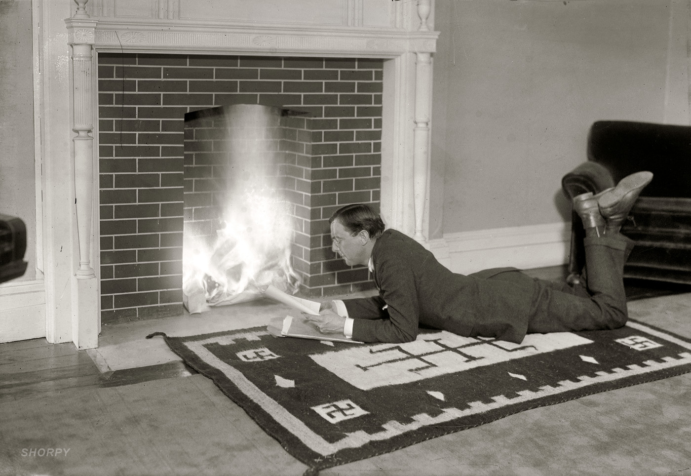 New York circa 1919. The producer, playwright and director  Stuart Walker, who had a long career in theater and film, spending a quiet night at home tossing scripts into the fire. George Grantham Bain Collection glass negative. View full size.