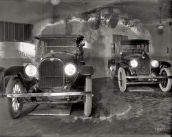 Washington, D.C., 1919. "Snelling Motor Co., interior." Two used American Sixes. National Photo Company Collection glass negative. View full size.
Early MarketingNot sure showcasing pans under the cars catching leaked oil is the best marketing strategy.
No drips=no oilThese early automobiles all dribbled a bit.  The only time they don't drip is if they don't have any oil in them.
American SixA good example of the "assembled cars" that were popular during this era -- engine and other components purchased from various suppliers and put together in Plainfield, New Jersey. The racecar driver Louis Chevrolet was billed as the firm's chief engineer. The parent company, American Motors, had no connection to the American Motors formed in the 1950s.
(The Gallery, Cars, Trucks, Buses, D.C., Natl Photo)