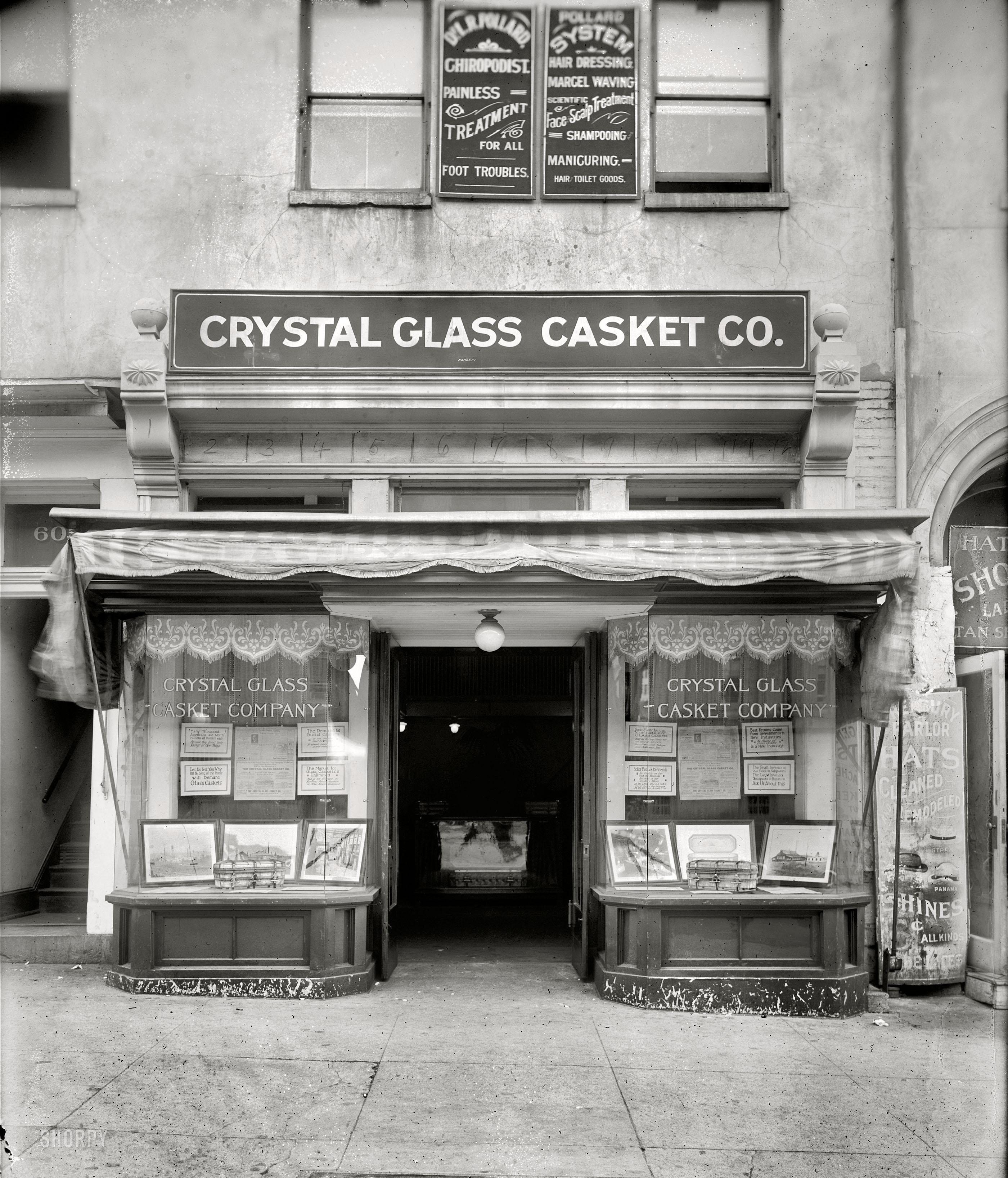 Washington, D.C., circa 1920. "Crystal Glass Casket Co., exterior." The offices of Crystal Glass Casket ("Let us tell you why 90 per cent of the people will Demand Glass Caskets") at 605 15th Street N.W., "directly opposite U.S. Treasury." This was the start of a "business opportunity" that ended with predictable if not entertaining results -- a million-dollar swindle, indictments for stock fraud, conspiracy and bribery, and trials that dragged through the courts for years. National Photo Company Collection crystal glass negative. View full size.