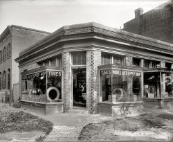 Washington, D.C., circa 1920. "Moore's Auto Supply Shop, 20th & K streets N.W." Next door at Bowie's Tonsorial Parlor: "Hair-Cutting by Electricity." In addition to the usual services of facial massage and umbrella repair. View full size.