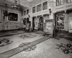 1920. "Crandall's Savoy Lobby." In this Washington, D.C., movie theater, lobby cards for "Dangerous to Men," "Youthful Folly," "Reclaimed" and "Treasure Island." National Photo Company Collection glass negative. View full size.
Fame and DeathInteresting that Olive Thomas died in rather sordid circumstances the year this picture was taken, while Viola Dana lived on until 1987. At any rate, what a gorgeous poster that was for "Youthful Folly"!
The PickfordsSpeaking of the Pickfords, I do believe I see a photo of Mary over there on the left-side wall:

It seems that woman was everywhere in the late 'Teens and early 'Twenties!
What a way to make an entranceThat tile floor is spectacular!  Wish I could see it in color.  
Gilded PopcornI really would love to see the snack stand actually.  I can just imagine the elegance of it.
GorgeousThis is a truly gorgeous lobby, reflecting the new respectability that movies had achieved in less than a decade. Inside for evening performances at least, there would most likely have been a small orchestra playing during the film, with music cues sent along by the studios. The myth of the little old lady playing a rinky-dink piano and deciding on the music based on the mood of the scene wasn't entirely wrong but at an establishment like this, in a city like Washington it was hardly the norm. Indeed, one of the repercussions of the advent of sound in movies was the sudden unemployment of musicians who, up to that point, had played in movie theaters.
The Movies:
Let's start with "Treasure Island" which is unusual in that the poster doesn't name the cast - Maurice Tourneur, whose name is as large as the name of the film, was the director as well as the film's producer. He had an extensive career in silent movies in Hollywood before returning to France when sound came in. Like most of his work before 1922, he shot it the New York area - Fort Lee New Jersey had been the "first Hollywood." The film, now considered lost, starred 55 year-old Charles Ogle, who had been a leading man in the early movies, as Long John Silver, Shirley Mason as Jim Hawkins, and Lon Chaney as Pew. Mason was the younger sister of Viola Dana, who starred in "Dangerous to Men."
There seems to be nothing known about "Reclaimed" (full title "Reclaimed: The Struggle for a Soul Between Love and Hate"). It stars Niles Welch and Mabel Julienne Scott, of whom we know just slightly more than we know about the film.
"Dangerous to Men" was a comedy starring Viola Dana and Milton Sills. The actors are quite famous but the film seems to be lost. Sills came from a wealthy family and had been a professor of Psychology and Philosophy at the University of Chicago before he was bitten by the acting bug. He had a very successful career, and made the transition to sound easily, starring as Wolf Larson in the 1930 production of "The Sea Wolf," but died suddenly of a heart attack at age 48. Viola Dana (born Virginia Flugarth) on the other hand lived to the age of 90. Her first husband died during the Spanish Influenza epidemic. She talks about her experiences in Hollywood (including the death of her lover, pilot Ormer Locklear) in the TV series "Hollywood" by Kevin Brownlow and David Gill (well worth seeing, if you can find it).
Olive Thomas, who starred in "Youthful Folly" is one of the great Hollywood tragedies. Born in 1894 as Olive Duffy, she came from a working class family in Charleroi Pennsylvania. She was briefly married at age 16 before going to New York to work in a Harlem department store. She entered a contest for the "most beautiful girl in New York" and won. This in turn led her to become the star of Florenz Ziegfeld's rather racy "Midnight Frolics" where she was often dressed only in balloons. She made the jump to movies in 1917, the same year that she married Jack Pickford, the brother of Mary Pickford. The relationship was stormy in part because of Pickford's alcoholism. Both of them enjoyed the partying lifestyle. In 1920 they went on a second honeymoon to France. During their stay she drank a liquid solution of mercury bichloride (prescribed for her husband's chronic syphilis). Although there were rumours of suicide or murder, the subsequent investigation ruled her death accidental since the label of the bottle was in French. She was 25 years old when she died. Before her death she starred in a picture that gave a name for the women of the decade: "The Flapper."
It&#039;s OK I guessI mean if you like elegance and stuff. I like loud places, with fluorescent lights, where you can't concentrate on anything at for more than 3 seconds. This place doesn't look like it has video games, slushies or any movies by Jerry Bruckheimer.
And the movies probably suck eggs because they're so cheap and you can watch like three in a row ... and those posters look like somebody drew them, I mean don't they have a camera, or a computer ... and why isn't everything in this picture catered to children 8-12 years old? I don't see any cartoons. Where are the cartoons!
Elegance, craftsmanship, artistry! Where's the pretzels covered in cheese?
(The Gallery, D.C., Movies, Natl Photo)