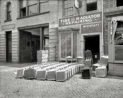 Washington, D.C., circa 1920. "Wittstatt radiator shop, 13th Street N.W." National Photo Company Collection glass negative. View full size.
Wittstatt&#039;s 2009The company is still around but has changed its name and location. The Web site carries the Wittstatt name.   It's now Virginia Auto Service, in Falls Church. They're still doing radiators!
http://www.vaautorepaircenter.com/services.nxg
Wow, free airand those radiators on the left look like Model T Ford, be nice to have those tucked away for the superannuation fund!
[The shop specialized in Emco brand replacement radiators, "guaranteed for Fords." - Dave]
Where the air is freeIs Whittsatt a word or a family name?  Great repair shop photo.  I love the stacks of identical radiators.
[Wittstatt, not Whittsatt. Edward L. Wittstatt, who had 10 more years to live. - Dave]
Mr. Davis and the MarinesWhatever happened to Mr. Davis, I wonder? It looks like someone tried to paint him out of the picture, literally.
I also wonder if that lone piddlin' garage bay was shared by the radiator shop and the Marine Quartermaster's Department. Those would be some pretty cramped quarters just for the radiator shop, let alone to be shared. But I don't see any other bays, not in this photo anyway.
Cool!(Well, what else can you say about a display of radiators?!)
13th StreetI was just in DC last weekend, and walked down 13th NW many times...I don't think this building exists anymore, and was likely wiped out to create the Ronald Reagan Building.  
[This part of Washington was cleared in the 1920s and '30s to make way for government development in the Federal Triangle, long before the Reagan Building went up. This stretch of 13th Street no longer exists. - Dave]
Cool, Man!Statistically, only the Ford Model Ts would have the demand for 75 radiators. Those are aftermarket replacements for 1917 models and up, sans the Ford logo.
[As noted below, the shop specialized in Emco replacement radiators for Fords. - Dave]
The darker ones in front of the door are from larger trucks. The ones at the far right look like honeycomb-style jobs-- great coolers, expensive, difficult to repair, and found mainly on high-end cars.
Deja GuangzhouThis photo reminded me of many of the businesses I saw in China when I was last there in 2000, guys assembling windows or appliances or furniture on the sidewalk outside a storefront.  The most interesting were the photo-etching artists, who used a tiny hammer and chisel to reproduce Westerners' photos on small marble plaques.  I had always thought those things were machine-made.  In many ways China's economoy and society parallels that of ours 100 years ago.
Fill in the blankThe blank space over the door is just begging for someone to finish the slogan. "Wittstatt -- Best Place in Town to Take a Leak"
Our family business!My dad, Ralph Wainwright, was a co-owner of Wittstatt's for decades. The business was sold to a man named James Ewin when Mr. Wittstatt died, and my dad went to work there as a mechanic when he was just 16. This was when the garage was on 14th Street in the 1930's. Dad was good at what he did and Mr. Ewin made him a partner in the business. They also owned shops in Roslyn, one on Washington Blvd. in Clarendon, one in Bethesda, and one in Falls Church, in addition to the Brightwood Garage in DC. I spent a lot of time as a kid in the 50's hanging around the tanks where radiators were cleaned!
(The Gallery, Cars, Trucks, Buses, D.C., Natl Photo)