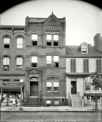 Washington, D.C., circa 1920. "809 Ninth Street." A good location if you need some printing done. National Photo Company glass negative. View full size.
UPDATE: This is the scene of the "Greek murder" whose victims were shown here two years ago. Thanks to Cnik70 and Stanton Square for their detective work.
SpookytownAnother Parallel Universe shot. Obviously those children have seen us and startled as we see them and startle. The watchful eye of the Matron dares us to make a move, even a false move. And this before I saw it's the Murder House. Cool.
Another lady in the windowShe's trying to be unobtrusive, but we see you ... Stood still long enough to register clearly, unlike the children and the passing man.
Gallaudet PennantDoes the pennant hanging approximately beneath the "D" in the Word Art Press sign read "Gallaudet"? Sure looks that way to me. If so it would be fitting that the college be recognized alongside Georgetown and other area institutions, though odd because at the time it was called "Columbia Institution for the Instruction of the Deaf and Dumb and Blind" and would not be named Gallaudet College until 1954. Edward Miner Gallaudet was the school's first superintendent and his father was the founder of the first school for the deaf in the U.S., but would that rate a pennant?
Can someone with better eyes and/or a better computer screen confirm that the pennant does indeed say "Gallaudet"? If so, may the mob-source wisdom of Shorpydom provide an answer to the question of the anachronistic pennant.
[Hardly an anachronism -- the name Gallaudet College has been around since 1894. - Dave]
W.B. Dawson: Radio Enthusiast

Washington Post, May 7, 1924 


Listening In

Radio Editor:
Kindly Tell me through your paper if there is such a station as CHYC, Montreal, Canada, and what is the mileage?  At 9:55 last night (Sunday) I heard music broadcast by a Mr. Root, Montreal, Canada, I am quite sure.  Thanking you for any information. W.B. Dawson, 807 Ninth street northwest. 
ANSWER &mdash; CHYC as listed on The Post radio map is a broadcasting station of 2,000 watts power operating in Montreal, Quebec, on 410 meters. The station is owned by the Northern Electric Company and broadcasts in English.  The station is approximately 495 miles distant from Washington.

Check OutThat superb masonry work on 809.  Hard to duplicate today. And the stained glass glazing above the ebtry doors and the first floor double window. A lost art.
Look out belowThe birthplace of the old flowerpot-on-the-head gag. A true comedy classic.
Scene of the CrimeThe account of this grisly murder reads like the back-story of a George Pelecanos novel.  The subplot: a crime of deception and betrayal goes tragically wrong.    The characters: Greek immigrants working in the restaurant trade. The location: inner neighborhood of Washington D.C.



Washington Post, Jul 26, 1920 


2 Slain, Third Dying
Man and Woman Lose Lives in
Affray in Ninth Street.
Police Believe Tragedy Followed an Attempt at Robbery.

A man and a woman are dead, and another man is mortally wounded as the result of a shooting and cutting affray in a rooming house at 809 Ninth street northwest, early yesterday evening.
The dead are Katherine Odiscus and Theodore Apostalos Koukos.  Jean Odiscus, believed to be the husband of the woman, is in Emergency Hospital in a critical condition.
A roomer at the house, hearing four shots about 6 o'clock, summoned Patrolmen Page and Murray of the First precinct, who removed the victims to Emergency Hospital in the patrol wagon.
Physicians at that institution said that the wife died before she reached the hospital as the result of two bullet wounds to the head.  Koukos died as the result of several hatchet wounds about the head, believe to have been inflicted by the husband.  Odiscus is suffering from two bullet wounds in the head.

Clew in a Post Card.

A .32-caliber revolver with four bullets discharged and a blood-stained hatchet were found lying on the floor near the bodies.  Koukos was found lying face downward at the foot of a small flight of stairs where he had fallen.  He was partially clad when picked up by Patrolman Davis, of the First precinct, who took the victims to the hospital.
The woman was lying on the floor of a hall a short distance from her bedroom door.  The husband was discovered lying across the threshold of his room with two bullet bounds in his head.
A postcard addressed "Dear Phillip," and signed by a woman stating that she was leaving for Wilmington, S.C., was on the bureau.  Four new suitcases hurriedly packed, were standing on the floor of the room and appeared as though they had been dropped by some on in flight.  A razor, which had just been used, was found lying on a dressing table.
Mrs. Minnie King, proprietress of the boarding house, said that Koukos and Odiscus applied at the house late Saturday night for a room.  They say that the sister of Odiscus would arrive later in the night and engaged a room for her.  Odiscus said that his sister was French and spoke no English.  He said that he had formerly roomed with Mrs. King, although the woman has no recollection of him.

Story Told by Mrs. King.

Shortly after the two men entered the dwelling the girl is believed to have arrived, taking the room which had been engaged for her.  Mrs. King told Lieut. Sanford and Detective O'Reilly that she had no knowledge as to the exact time that any of the trio entered the house for the night.
No other roomers in the house saw either of the three persons at any time yesterday, although it is known that they left the dwelling sometime in the forenoon and returned shortly before the tragedy.  The theory advanced by the police for the killing is that the husband and wife lured Koukos from his home in Norfolk, Va., representing the woman to be single, for the purpose of robbing him.

Theories of the Police.

Reconstructing the tragedy Lieutenant Sanford said that probably the husband and wife entered Koukos' room when the latter was asleep and attempted to slay him by beating him over the head with a hatchet, which the husband is known to have incurred before engaging the room. 
It is thought that Koukos managed to gain his feet long enough to procure a revolver and then retreating toward the starts shot and killed the woman and fired two shots which may prove fatal to the husband.  The murdered man is thought to have made an attempt to raise some one in the dwelling but succumbed to his wounds when at the head of the stairs.
Police last night declared that Odiscus formerly worked in a restaurant in Washington.  Letters found in the room indicate that the husband and wife were separated several times and that the man in his effort to locate the woman traveled in several cities in Virginia and North Carolina.

$1,900 Found on Body.

It is practically certain, police say, that the man and woman going under the name of Odiscus were in collusion to rob Koukos and got him to come to Washington to marry the girl who was posing as his sister.  Greeks consulted in this city who allege to have known Odiscus last night definitely identified him as a husband of the woman. 
A money belt containing $1,900 in bills of large denominations was found on the body of Koukos when on the operating table at Emergency Hospital.
Police are endeavoring to locate any relatives of the three.  Passports out of Greece were found in the baggage owned by the man and his wife.  It was by this means that their names were procured.  An inquest will be held over the bodies of the man and woman at the morgue this afternoon.

[And there's more here. - Dave]
&quot;Shining&quot; prequelNo wonder all that mayhem and murder occurred here. The two sisters from  the Overlook Hotel are standing there checking everything out. 
Greek MurderI thought this sounded familiar. This is directly related to this previous post.
[Brilliant! I saw the two photos side by side yesterday when I was posting this but did not make the connection. - Dave]


Local colorJust posted a colorized version on my blog. Sorry, it's a bad habit.  I can't stop myself.
MintyThis site's now the location of the US Mint and the new Cuba Libre restaurant.
(The Gallery, D.C., Natl Photo, Stores & Markets)