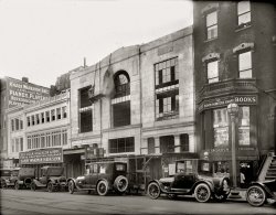 Washington, D.C., circa 1920. "Harry Wardman property, 1340 G Street." National Photo Company Collection glass negative. View full size.
John Dabney: Barber to Presidents.The ground floor barber shop at 1344 G appears to have been the business of semi-famous barber John W. Dabney.  A 1901 article regarding his hair tending activities is below: Dabney's clientele list is a who's who of the day's prominent politicians.  I find the news article additionally interesting for the details of President McKinley's grooming regimen.
I believe (but can't be positive) that the owner of "Dabney's" in this photo to be the same person based on two additional factoids:

The Post's legal notices, Jun 5, 1913, include reference to "John W. Dabney, 1344 G Sts. N.W."
 Census records list only one John W. Dabney in the relevant period.  The 1920 census cites him living at 618 R St, age 63, mulatto, born in Virginia, occupation: barber, owns his own shop.




He Shaves Great Men
Barber Whose Razor Moves Over Familiar Faces.

Over a little shop in an F street basement there presides a man who has perhaps pulled the noses of more distinguished men than any other man in the country.  Withal he has pulled them gently, and has for years been a great favorite of men who have thus been assailed by him.  He is John W. Dabney, a colored barber, who is the special barber of the President of the United States and of two score of other public men, who compelled to be shaved like ordinary mortals, delight in having that duty well done and with due regard to their own comfort and convenience.
There are three sets of official barbers in Washington, the Executive, the Senate, and the House of Representatives, but the dean of this corps is, or course, the man who shaves the President, looks after his hair, and keeps the Executive scalp in good condition.  Dabney is an artist in this line, and one of the most modest of men.  He is not talkative.  He has never yet contracted the failing of the average barber, and no man who wished to sleep would be kept awake while under his care.
It must not be inferred, however, that President McKinley does not know how to handle a razor.  He has all the accomplishments that belong to the first gentleman of the land, and shaves himself every morning.  Dabney is an occasional visitor only, and he becomes the official barber when the President's hair needs trimming and when his scalp demands attention.  This occurs about once a week.  There is a barber's chair at the White House, but is has fallen into disuse.  The President sits in an ordinary easy chair while Dabney spends the hour and a half usually required to properly dress Mr. McKinley's head and shave him.  The Presidential face is somewhat tender and demands some care.  His beard grow "stout" and must be handled gingerly.  In the chair the President is one of the most pleasant of men.  He talks freely and discusses current matters of the day, save politics.  That he carefully eschews.  He enjoys the operation, chats entertainingly, and after his head has been rubbed and scalp treated, as Dabney only knows how to treat it, the President expresses his satisfaction, and goes about his arduous duties refreshed and contented. 
Then Dabney returns to his shop and waits on ordinary mortals or makes the rounds of the houses where he is daily expected in his duties and require him to care for the hair of ladies of innumerable official families.  He is, as a barber, one of the most familiar figures in many of the leading families in Washington.  For thirty years he has wielded the scissors and razor, and twenty-three years of that time has been spent in Washington.  Among those now living whom he has or is servicing are, besides the President and Mrs. McKinley, Secretary Root, Secretary Long, Vice President-elect Roosevelt, Senator Frye, former Vice-President Stevenson, Justice Harlan, Gen. Miles, Admiral Dewey, Senator Hoar, Senator Carter, Gen. Clarkson, Henry Watterson, Gen. Tracy, former Secretary of the Navy, former Senators Murphy and Smith, and others.
Among the distinguished dead who were habitues of his shop were James G. Blaine, Secretary of State; W. W. Corcoran, philanthropist; Secretary Windom, of the Treasury; Secretary of Agricultural Rusk, Senator Farley, of California; Senator Vorhees, of Indiana, and many others. ...
Discussing the habits of great men in the chair, Dabney said: "Mr. Roosevelt was always chatty.  He discussed anything that happened to be the center of public attraction, politics, prize fights, sports, religion, or anything that people were talking and thinking about. Blaine and Corcoran were reticent.  They had little to day, but were always pleasant.  The German and French ministers like their own peculiar foreign hair cuts, expressed the satisfaction when well served, but did no talking.  Secretary Root likes good attention, is pleasant and agreeable, but reserved.  Secretary Long is a man of few words at all times, and fewer still when in the barber's chair.  Former Vice President Stevenson had a pleasant word whenever he entered the shop, took everything good naturedly, and was easily pleased.  Few men are testy when under the scissors or razor, in you only study what they like and endeavor to give it to them."
Since his appointment as the White House barber three years ago, Dabney has had many calls, not only for prominent officials but from many ladies, wives, of Cabinet officers, and others in Congressional and exclusive social circles, whom he attended for hair and scalp treatment.  One interesting thing in connection with his work is the fact that he has been of student of his profession and refuses to use any of the numerous so called remedies for the scalp with which the market is flooded.  He uses his own shampoos, tonics, &amp;c., which are compounded by himself.  This secret, whatever it is, is zealously guarded by him, but he proudly asserts that the ladies of Washington society whom he treats regularly and whose hair he keeps in order commend him for the excellence of his work.  As a successor to Charles Leamis, who has been identified with the White House since Grant's first term, Dabney seems to have been succesful and to have won the favor of those with whom he comes in contact.
...
[article goes on to detail barbers of the House and Senate] 

Washington Post, Feb 3, 1901
also appeared in The Colored American, Jun 29, 1901


Dabney's 
The Young Visiters"The Young Visiters" was written by Daisy Ashford when she was 9 years old (though not published until some years later).
The full text is available at project Gutenberg.
No ParkingI wonder how much a parking ticket was back then? 
Still waitingIt looks like it's still for lease (or at least part of it) after 88 years ...
View Larger Map
Wutta View!Shame about the "facadomy" applied to the face of this building over the years.  The original architecture was handsome and robust.  Trivia: I believe that's the roof of the Willard Hotel (14th &amp; F Streets N.W.) appearing to the upper left of the subject building. The sign announcing the "smokeless boilers" may refer to the site's having natural gas service to supplant coal use-- the "smokeless" feature can be thought of as an antecedent to today's "green" technology. The streetcar tracks seen here belonged at the time to the Washington Railway &amp; Electric Company, later becoming the Capital Transit Co.'s Route 20 line, which covered a LOT of territory from Bladensburg, Md., in the east of Washington to Cabin John, near Great Falls to the west of the city.  The "No Parking" sign was not taken seriously, if only because of its homemade look.
["Smokeless" generally meant coal-fired downdraft boilers. - Dave]

Double JeopardyFour of the five cars with visible license plates have 2 plates.  One plate on each car is D.C.  Can anyone know what the other one was and why the cars had two?
[Those are Maryland plates. In the days before motor vehicle reciprocity, a driver might need to have a license plate for every jurisdiction he drove in. - Dave]
Heads UpLook out! Mind the flowerpots!
Electrical Massage?Dabney's, under the bookstore, is apparently offering "Electrical Scalp and Facial Massages."  YOW!
You know, I love these old photos because, often as not, they remind us of how much we have in common with the people in them, in spite of the funny technology and hairdos.  
This is NOT such a time.  Electrical Face Massage?  They... run 120V through your face?  
I hope that I'm just ignorant of the process.
Harry WardmanIndication is, Harry lost his fortune in the 1929 Wall Street crash.  He had amassed $30 million.  Wouldn't a lot of it be in his vast real estate empire?  That would also have been depressed, but not like the stock market.
Autumn 1920I am always curious when Dave states something such as "circa 1920." To what extent is such a statement based on information attached to the photo and to what degree is it based on Dave's own research and intuition?
In this case, Dave, is indeed, quite accurate.  I date the photo to Autumn of 1920, bracketed by the following  Washington Post articles:

 Sep 26, 1920: Bellevue Farms Lunch (located behind the photographed construction signage) at 1334-1336 G st, had acquired #1332 G street and the premises were being remodeled to serve as the "Bellevue Annex, Dining and Tea Room," (matches signage seen in photo)
Dec 13, 1920: Advertisement announcing beauty services at Maison La Vigne, recently opened by Beatrix La Vigne Erly at 1342 G St. (this address still under construction in photo)
Jan 8, 1921: Bellevue Farms Lunch advertised that the former annex at 1332 G street is now functioning as "The Bellevue Bantam," a home style dining room serving "the same delicious Bellevue food." (signage in photo not yet updated reflect this name)

[The year is on the license plates. If the numbers aren't legible, you can often tell by the design. - Dave]

Still thereI work across the street from those buildings. They've been abandoned for approx 7 years (most recently they were the site of an adult bookstore/tattooist and palm reader). The bookstore building has been gone longer than that and is just a deep hole now. Just last week they've started to clean up the empty site of the bookstore, to make way for a new building which will be part of the Armenian Holocaust Museum being built there and in the old National Bank next door on the corner.
That's not the Willard in the background. The Willard is off the right side of the picture, 1 block down.
This stretch of G Street between 13th and 14th is one of the last "underdeveloped" areas downtown. Looking forward to some of the luster coming back.
+90As edition_of_one noted with the Google Street View, two of the buildings still exist although they are still vacant and have been for several years.  Prospects for tenants aren't great.  Below is the identical view taken in April of 2010.
Now goneAn update: These buildings have been demolished. The D.C. government threatened to declare them a blight and gave the owners a deadline to demolish them, otherwise the property taxes would have increased dramatically.  The demolition began a bit before Christmas and seems to have mostly wrapped up over the past MLK holiday weekend (Jan. 18-20).  Here's a WBJ story from last year about the fate of the buildings:
http://www.bizjournals.com/washington/breaking_ground/2013/04/dc-buildin...
(The Gallery, Cars, Trucks, Buses, D.C., Natl Photo, Stores & Markets)