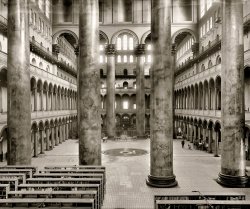 Washington, D.C., circa 1918. "Pension Office interior." This former repository of Civil War veterans' pension records is now the National Building Museum. National Photo Company Collection glass negative. View full size.
At one time in the early 1960s,this grand old space was used as overflow office space  for employees of the Civil Service Commission (now the Office of Personnel Management).  The building had not been maintained very well, and apparently had many unsealed openings to the outside.
A friend who worked there put up with temperature extremes and vermin.  The only pleasant distraction was watching the antics of the birds which flew freely around the great atrium space.
Remarkable DesignI think the design of the building is remarkable. The offices where the hundreds of clerks toiled are around the periphery. It was built LONG before air conditioning. The taller central area must provide a sort of flue where the hot air rises bring in fresh air to the offices. Montgomery Meigs did a pretty good design.
Still there and lovelier than everAs the National Building Museum, this great central space is the first thing you see as you walk in the door. The columns are there, exactly as shown (they are hollow, painted to look like marble), the central fountains and loft ceiling make this one of the pleasantest public spaces in the nation's capital.
Can you imagineCan you imagine the government building anything even remotely like this spectacular structure today for the purpose of storing pension records?  The contemporary version of this would be a windowless, poured concrete atrocity full of cubicles, computer terminals, and fluorescent light bulbs, i.e., hell on earth.
Exit question for iamfelixExit question for iamfelix ("Lovely").  This would have consumed the entire tax receipts of how many US citizens in 1918?
[This building was 30 years old when the photo was taken. It cost $886,000. Construction commenced in 1882 and lasted five years. It was commissioned by Congress in 1881 as headquarters for the Pension Bureau, a huge department responsible for handling benefits for the country's thousands of Civil War veterans as they began to enter retirement age. Congress stipulated that the building be both inexpensive and fireproof. Considering that it's lasted for well over 100 years, I'd say the taxpayers got their money's worth. - Dave]
Then and NowHasn't changed very much! 
Land of the giantsVery imposing building, I'll bet you that would feel very small when you entered.
WowThe corinthian columns are both massive and gorgeous. I wonder how they compare size wise to the ones holding the roof up on the Hagia Sophia. 
FacesThank you for this photo.  My father has loved this building all his life and often mentioned the faux-marble columns, saying that people claimed they could see the faces of the dead soldiers looking at them from the marbled paint, then shifting back to marble again.  It was hard, as a child, for me to picture this; by the 1970s, these columns were painted beige.  I can see what he meant now.  
Superb!By anyone's definition, a truly Grand Space! Extraordinary!
Depressing WasteI don't know which is more depressing -- the sheer vulgarity of this massive government temple or the tragic war records it housed. 
Temple of the BureaucratA temple of the bureaucrat, with marble pillars and tile floors along with at least three barriers to get to the business end of the building. And no one fixed the fountain as it overflows on the tile. 
Restored!The National Building Museum has restored the space.  It looks much like it did when the photo was taken.  The Files are now gone and the tile floor is now carpeted except for a cut-out exposing the shield between the columns.  The fountain spray is configured differently now, too.  It is now a tall column of water rather than a multiple sprays.  
This is one of the most impressive interior spaces in Washington and is well worth a visit to see.  The view of the exterior of the building as you come up from Judiciary Square Metro Station is incredible, too.  It is probably the most dramatic view from any Metro escalator.
Atrium VentilationDepressing waste? No.  As has been pointed out, it was built long before air conditioning, and the central court was designed to ventilate air to the roof, as well as the high ceilings on each floor. It housed 1500 workers when the pension department was expanded in a short time.  And the court was also intended for ceremonial occasions as well -- several presidential inaugural balls were held here.  
Interestingly also, the designers made sure to include a freed slaves in the frieze running along the outside.
From a different eraImagine the outcry that would ensue today, if the Federal or State government erected a bureaucratic building with such costly grandeur? A backlash would result, and legions of people would assail it as frivolous, costly, and inefficient government expenditure. 
In the 1920s they could have gotten away with something like this. But that was certainly a different era, a different time.
[This building was constructed in the 1880s. Completed in 1887. - Dave]
Hi-Tech VentilationOne of my favorite buildings in D.C. ...
The Anonymous Tipster is correct in noting the good ventilation achieved in the building.  Montgomery Meigs paid special attention to issues of ventilation in his design: in addition to the clerestory windows at the top, the masonry was constructed with special passages for air flow.  When in use, a special team was employed to run around the building, opening and closing windows during the day to adjust the air flow.  Meigs estimated that the air in the Great Hall could be exchanged every two minutes.
LovelyI don't find it depressing or a waste.  I think it's beautiful.  Why should public spaces be ugly and soulless, whatever their function?  There's more than enough ugly.
They&#039;re Brick ColumnsThose beautiful columns, in this, one of the best buildings I've ever seen, are laid-up bricks. Then plastered and painted to look like what the budget could not afford: marble. And the building was used for an inauguration ball not very long ago.
Eeeww!Are those spittoons on the floor by the colonnades? Every time I look, there's another one!
A bargainI'm very much offended by government waste, but this building is not anything like that.  If it cost $886,000 to build back then, that's only about $18-$19 million in today's dollars.  To put that in perspective, the recently opened new Birmingham, Alabama, office for the Social Security Administration cost $135 million, and in my opinion it's not remotely attractive.
50-50It's fascinating that the comments seem to be pretty evenly split: about half complaining of the waste and ugliness of the building; and about half seeing the beauty of the building and stating that the citizens certainly got their money's worth. I've never been to the building personally, but it's awe inspiring to me. Next time I'm in D.C., I'll most certainly track it down.
National Building MuseumI live in the DC area, and have visited this building a number of times. I consider it a very fine example of architecture, and an interesting place to visit. I find it astonishing that some people consider this beautiful 125-year-old building to be a waste of money. Geez, if this building is bad, I'll bet the national monuments, art galleries and other museums in Washington would REALLY be considered "frivolous."
NBMI visited this building on my vacation this summer, and absolutely you do feel small upon entering it.  The staircases with low risers are interesting also.
Not only is the building a pleasure to look at, but it has quite a few very interesting exhibits about Washington (all free, though they recommend a donation of $5), and an amazing gift shop with books on design and architecture.  Many of the exhibits show photos similar to the ones on this site.
One of the newer exhibits on green building explains that when the building was new it had awnings on the windows as another temperature control feature.  The windows are also placed to get sun in different ways in different seasons.
I had never heard of this building or the National Building Museum until I happened upon it while wandering around and stepped in. I'm very glad I did.
(The Gallery, D.C., Natl Photo)
