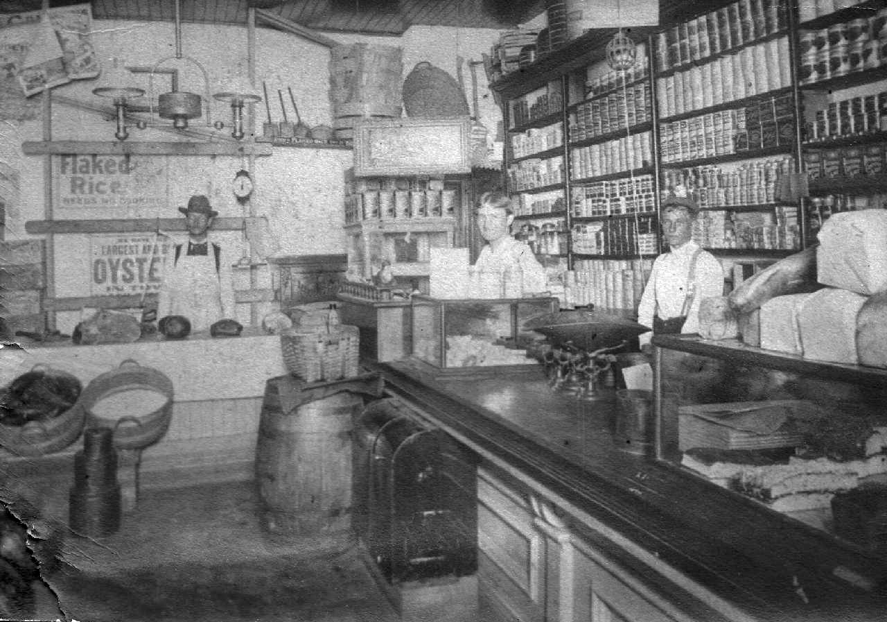 The interior of the Volkert grocery store at 24th and W. Warren, Detroit, in 1920.  The man with the hat by the "oysters" sign is Conrad Volkert. Names of the two "helpers" are not known.