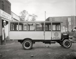 Washington, D.C., circa 1924. "Continental White Line bus." Who can pinpoint the location here? National Photo Co. Collection glass negative. View full size.
That hatIs that a smashed hat in the foreground? Very nice omnibus.
LocationI think it's right in front of the Atkinson Garage Company.
Air!It doesn't appear that there was a great deal of ventilation for this omnibus. In a time before antiperspirants and in wool clothing, no ventilation would be a bad thing. I can just imagine some of the tours were rather ripe. 
It could smell like the Lancaster County Farmer's Market on a rainy Friday in July after the Amish have been picking corn all week. The kind of smell that's nearly visible.
[The four-section windshield is hinged and opens for ventilation. Deodorants, which go back to the 19th century, were well established by the 1920s. - Dave]
Atkinson GarageAccording to an ad in the Washington Post (May 7, 1922), Atkinson Garage was in "Blagdon's Court" between 9th and 10th, M and N Streets NW.
[That didn't take long! Now called Blagden Alley. - Dave]
1244 Blagden Alley NWView Larger Map
Little has changedBetween the photo and the Google pic. Can even see where the drain cover in the foreground was -- the dark circle on the left in the Street View.
[Wouldn't it be funny if that hat was still there. - Dave]
&quot;Auto Repair Inc.&quot;Another view of the old garage in Blagden Alley. Note the ghost lettering on the beam across the garage door. Google Maps goofed on the street name's spelling!

PsssssstI don't think I'd have a lot of faith in that right front tire.  It looks like a bad "re-capping" job is about to delaminate - blowout!
You Da&#039; Man, Cranch!This is the sort of thing that makes Shorpy the best website ever.
Re: That HatBy day: dutiful civic transport. By night: wanton destroyer of ladies' millinery.
Gorgeous!I'm not usually very interested in vehicles of that age but that's got to be one of the most beautiful bus bodies I've ever seen. The designer was obviously someone who saw coachbuilding as an art rather than a job; just look at the sweep of the roof line - there's not a straight section in it. 
I&#039;m so lucky!How lucky am I? My software business is located directly across the alley from this building. Blagden Alley rocks; we love being there amongst the history, trying to build something new.
The New Blagden AlleyAtkinson Garage is soon to be open as R.J. Powers' restaurant Rogue24. The back doors of Wagtime and Long View Gallery are straight ahead. It's gratifying to see what is happening in DC these days, and wondrous and to see what was happening in DC those days. With a few decades of disrepair in between. 
Truck MarqueWhat is the name on the radiator/grille below the fluting on top of the radiator?  It appears that the manufacturer's name might be written diagonally below.
Also, note the interesting mechanical device attached to the door.  When the door opens up, the step automatically goes down.
(The Gallery, Cars, Trucks, Buses, D.C., Natl Photo)