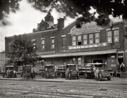 Washington, D.C., 1923. "Whistle Bottling Works." Yet another outpost in the Whistle beverage empire. View full size. National Photo Company Collection glass negative. Somehow I can envision a musical based on this place. Kind of like "The Pajama Game," but instead of sleepwear, soda pop. And of course whistling.
The secret of Whistle unearthed!With help from inventors.about.com:
In St. Louis in 1919, Charles Grigg invented and marketed his first soft drink, an orange flavored beverage called Whistle.  After a dispute with management he moved on to invent another orange drink, but still couldn't compete well with Orange Crush. He then toyed with lemon-lime flavor and in 1929 formulated "Bib-Label Lithiated Lemon-Lime Soda." The name was quickly changed to "7-Up."
[Fascinating! Thanks. Some more Whistle tidbits in the comments here. - Dave]
Imagine the racket...as you drive that solid-tired truck down the cobblestone road with all those soda bottles in the back to rattle around. Not good for the carbonation, either. 
Boo.The resident ghosts may be seen in the upper windows of the works...
Vintage SignageI've become accustomed to the periods in vintage signage, but the closed quotation mark after Farber's is puzzling.  And I'm not sure if that's a Star of David after the name or if it is a German logo used by brewing guilds, as a previous commenter to Shorpy indicated. Perhaps Farber also operated a brewery?
The "ghosts" in the upper windows are also a mystery, although the ones on the left side must be a character logo used for the soda, a policeman with--you guessed it--a whistle.
Old Jueneman BreweryFantastic photo!  This is a portion of the old Jueneman Brewery  - a few blocks from where I live.
The Brewery complex took up an entire block in northeast Washington bounded by 4th, 5th, E and F streets. George W. Juenemann started his brewery business in 1858.  After George passed away in 1884, his wife Barbara ran the brewery for a few years before selling to Albert Carry in 1886.  Carry in turn sold the brewery to the Washington Brewery Company in 1890 and started his own brewery in southeast Washington.  The Washington Brewery Company brewed beer until the the Volstead Act was passed in 1917.  In addition to brewing, the complex included a beer garden for many years.  This photo seems to be looking south across F street just east of 4th.
The large tower of the Brewery is visible with the mournful sign "This Property for Sale." In 1925 the brewery complex was completed razed.  In its place was built the Stuart Junior High School, now the Stuart-Hobson Middle School.   Whistle Bottling works relocated to much smaller  facilities  on  North Capitol Street.
Volstead ActThe Volstead Act passed in October 1919 (over Woodrow Wilson's veto).  However, DC went dry in 1917 due to the Sheppard Act, three years before the 19th Amendment went into affect.
http://www.rustycans.com/HISTORY/prohibition.html#top
 4th and F streets N.E.Based on the fact that there are trolley tracks in the foreground, I think this is taken from F Street N.E. facing south. Today, there's a four foot high retaining wall and a playground where those trucks are parked.

Don&#039;t think the location is rightEither the date suggested for the building is wrong or the address is off. The peak of the building is marked either 1895 or 895 either of which would mean it couldn't be at the 4th &amp; F NE location. If 1895 is the date of the building then it wouldn't be the building referred mentioned as having been built in 1858.
[The location was 4th Street between E and F, as noted below. The building in the photo was constructed in 1895. The previous comment didn't say it was built in 1858 -- it said 1858 is the year the brewery was established. - Dave]
Whistle Bottle FoundI was putting a new floor in my house and found one of these nifty little bottles under the floor.
Amazing how old it is!
Traffic Motor Trucks"Largest exclusive builders of 4000-lb. capacity trucks in the world."
The four trucks to the right are Traffic Trucks made by the Traffic Motor Truck Corporation of St Louis, MO.  My guess is that these four trucks are circa 1918 - 1921.  The truck on the far left might be an earlier model Traffic Truck.  It appears that that the second and third trucks from the left are slightly older and smaller that the two trucks to the far right.
The sloping hoods with triangular sides as well as a radiator which extends very high above the hood of these vehicles are very distinctive.  The word "Traffic" can also be seen in the center of the top of the radiator.
Prices started at $1,195 in 1918, and rose to $1,395 in 1919, $1,495 in 1920, and $1,595 in 1921 for a 2-ton model.  Starting in 1922 there were also 1 1/2 ton, 3-ton, and 4-ton models.
Traffic specifications for 1919 were: 4-cylinder, valve-in-head, 40-h.p. motor; Covert transmission; Borg &amp; Beck disc clutch; Kingston magneto with Impulse starter; 4-piece cast shell; cellular type radiator; drop forged front axle with roller bearings; Russel rear axle, internal gear, roller bearings; semi-elliptic front and rear springs; 6-inch U-channel frame; Standard Fisk tires; 133-inch wheel-base; 122-inch length of frame behind driver's seat; oil cup lubricating system; chassis painted, striped, and varnished; driver's seat and cushion regular equipment.
The men on the truck on the far right almost seem to be Soldiers, but do not appear to be 100% in uniform.  They are dressed very differently from the other deliverymen.  There are American flags on the truck and a very interesting propeller looking hood ornament attached to the radiator.  Makes me wonder if they delivered to military bases around the D.C. area.
The second truck from the right appears to be carrying wine or champaign bottles just to the left of the driver.  Not likely since prohibition is in effect, but it seems a little odd to see that bottle shape here.
Note the opened windshield on the middle truck.  It looks like it would get in the way of seeing out or smack you in the face if you hit a bump.  Three of the other trucks have similar windshields.
I see only one dock door.  If a truck were to back up to the door it seems that it would stick out into the street.  There is not a lot of distance between the edge of the dock and the first set of trolley tracks.
At first I thought the leaves be trying to hide yet another of those round telephone distribution points, but looking closer it appears to be a set of lights around a smokestack.
Finally, what are the checkerboard-like objects in several places in the trolley tracks?  Are they signaling devices, insulators, or something else?
(The Gallery, Cars, Trucks, Buses, D.C., Natl Photo)