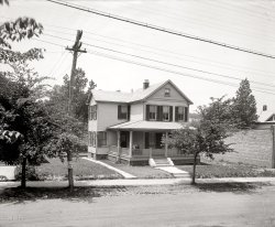 Washington, D.C., circa 1923. "Allied Asphalt Products Co., 3402 18th Street N.E." National Photo Company Collection glass negative. View full size.
Wish I Lived There...I would sit in a rocking chair on that front porch sipping iced tea (possibly strengthened with a little Black Jack) and sell Asphalt Products to passers-by.
Built 1911

Washington Post, Sep 17, 1911 


Building Permits

B.M. Artley, to erect two-story frame dwelling at 3402 Eighteenth street northeast, $1,375.  C.M. Chaney, architect; R. Dows, contractor.

Street parkingSomething seemed odd about this house and it finally clicked: it doesn't have a driveway!
There are other cities in the US and WorldDave ~
I realize it is your hometown, but enough of the D.C. photos already.  Please.  It's not a very attractive city and there is an entire world of historic photos out there - could we see some of those.  Please.
[There are two things (at least) you seem not to be aware of! - Dave]
What a nice houseI wouldn't mind a house like that. Very attractive. Today, it appears that there's a church on that lot.
And now ....View Larger Map
Do NOT talk to the neighborsThat's a pretty formidable brick wall on the right.  Assuming that there is just another house past it, I wonder what prompted someone to build such a thing.
That's the type of thing H.P. Lovecraft would have given a morbid reason for.
CharmingVery charming house that is fit to illustrate the phrase "good old days".  But, I don't like the curve of the pole on the left, and I wonder why the tall brick wall on the right?
Mighty oaks from little acorns growI wonder if the sapling in the original picture is the same as the grown up tree showing in the Google street view.  It looks to be in about the same spot.
The &quot;wall&quot; and street treeTwo things...the small street tree in the old picture, it appears to be the same cultivar as the huge tree in the modern street view.  Wonder if it is?  Also, the wall, appears to be the small single story storefront seen in the modern street view as well.
WallIs that a wall or the side of a building? If so, the building appears to still be there next to the driveway.
Ok, I&#039;ll bite...From previous comments....

I realize it is your hometown, but enough of the D.C. photos already. Please. It's not a very attractive city and there is an entire world of historic photos out there - could we see some of those. Please.
[There are two things (at least) you seem not to be aware of! - Dave]

Dave, what "two things (at least)" are you referring to?  I suppose the #1 reason is that one of the primary resources for the photos of this site is the Library of Congress in Washington, D.C.  Are you counting the two major contributing studios (Harris &amp; Ewing and National Photo Co.) as two distinct reasons?
Additionally, in response to the Anonymous Tipster, I believe the architecture of D.C. is both special and intrinsically attractive - it reflects the monumental architecture one would associate with a Capitol city as well as the American vernacular architecture  of the past two centuries.
Nice shuttersI was disgusted by the shutters on my own home--they had been added as an afterthought and were completely unnecessary. When the garage was tacked onto my house, the wall ended right beside a window, so the owners just put the window's other shutter on the garage wall, perpendicular to the window. So ugly. I thought to myself, the house was built in 1920! No way would they have done something so stupid then! But check out the shutter-work on this place. I guess I was wrong!
Sears Home?This looks very similar to a Sears home of 1908-1914.
http://www.searsarchives.com/homes/1908-1914.htm
Modern Home No. 159 has many of the same attributes as this beauty
Just around the cornerJust around the corner from
1804 Kearney Street N.E.
https://www.shorpy.com/node/5713?size=_original
DC Real Estate Records show
3400 - 3402 18TH ST NE
Owner Name:  	PURITY PENTACOSTAL DELIVERANCE
Mailing Address: 	3406 18TH ST NE; WASHINGTON DC20018-2722
DC Real Estate Records do not list a 3404 18th St NE
Side of a buildingThat indeed is the sloping side of the building next door. Dave, DC is fine. Keep it up
In My Humble OpinionI think the wall must have been the property line.  Looking very close, I think there is also a driveway between the house and wall, although it is not very well maintained, and it is very narrow.  Also it has a lot of grass and weeds in it.                                            Have a Great Day!
Off-street parkingRather than driveways, this area appears to have alleys.
Sorry, FreddieMiss Doolittle is not receiving visitors today. You are about 95 years early; we were expecting Mr. Shaw first.
Built 1911I am stunned to see the building permit notice from the Washington Post (see comment below). The builder-architect, C.M. Chaney, was my grandfather (mother's father). His full name was Conrad Marene Chaney, and he was a prominent housebuilder in Northeast Washington for many years. He is noted as one of the pioneers in bringing the bungalow-style house to the Distict. He passed away in 1938, a year before my mother was married, so I never knew him.
No drivewayIn the old days, neighbourhoods had these nifty things called back alleys. Most people parked their cars in detached garages that faced the alley. That way, if a car was left running or if a fire broke out residents wouldn't be in risk of their lives, and the street wouldn't look like a Parade of Garages. (Electric and other wires also ran down the back alley, and the city picked up garbage there.)
I'm not sure why I'm writing this in past tense, though, since I've never owned a house that didn't back onto an alley.
My Shorpy RoutineWhen the day is full with not a lot of time I'll view the photos then scan the comments to look for any [Dave zingers] - until there's time to catch up on the full list of the comments later. A classic Dave bit today.
Not my street, but around the cornerI live about four blocks from this house and walked down there to see what I could see about this place. There is indeed an alley behind this particular block, though not all blocks in our neighborhood have them. Also, if you look closely at the left side of this photo you can see another house behind the trees; I believe that house has been incorporated into the two storefront church now numbered as 3400/3402. (You can see it when viewed from the alley). I assume that the subject of this picture was demolished and replaced by the tan storefront and the little apartment walkup, I guess in the 1930s. Finally, I think the brick wall on the right side of this photo is the south wall of the dreary OOB "childcare center" that exists there today. 
As a neighbor, I sure wish there were something else on this block now, either homes or viable storefronts. These buildings are all essentially abandoned, having been vacant or "under renovation" for most of the ten years I have been in the area. There are dozens of storefront churches around...I can think of four others within three blocks of this site. 
(The Gallery, D.C., Natl Photo)