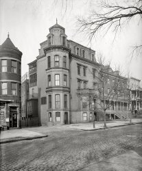 Washington, D.C., circa 1923. "Sherman house, 300 block Third Street N.W." National Photo Company Collection glass negative. View full size.
Beauty before FunctionI gasped with delight when I first saw this. It was a time when architecture was meant to be more than protection from the weather. Even the screened porches have decorative sunburst corners. The neighborhood then was obviously run down and we can be pretty certain this didn't last, but thank you to whoever brought us another picture of the past lest we forget. I wish to add that we used to take drives through D.C. just for the architecture but now one must go hunting to see anything interesting.
Fifth-floor walkupIsn't that Rhoda's apartment in the attic?
Long goneAccording to google maps, the area is now occupied by the Department of Labor and other office buildings. The whole area appears redeveloped. 
Alley ViewIn the alleyway there are two closely spaced windows that open from the top out. This is usually indicative of a standing stall for horses, though the rest of the building does not appear to be a stable.
&#039;Tis the SeasonIt's partly the photo and partly the season - Happy Twelfth Night, everyone! - and the Sherman house instantly recalled to me the classic Charles Addams cartoon from the New Yorker issue of 21 December 1946.

Next doorI saw some great examples of this style in Providence, RI, recently, but I am partial to the austere balance and symmetry of its neighbor: purely lovely, in spite of it being built for multiple dwellings. Give me more, Dave!
Tipton House?The LOC information associated with this photo has led me absolutely nowhere. Additionally, looking at the old Baist realty maps indicates that there is no place on the 300 block of Third street which conforms to this house and alley.
The most compelling nearby match I can find from looking at old maps, and it's purely speculative, is that the address is 218 Third street NW.  The building was known as the Old Tipton House.  It later saw service as the D.C. branch of the Florence Crittenton Mission.  Around the time of this photo, it was converted for use by the Women's Auxiliary of the American Foreign Legion as a home for veterans.
Too bad we can't see any house numbers, or more of the corner market - that could provide more clues.
Bigger Than a Bread BoxThe Bond Bread box in the lower left corner harks back to the day when bread companies made early morning dropoffs, and to the surprise of no one the bread was still there when the shop owner opened the store.
Bond bread was my choice as a child since it came with trading cards and I didn't have to spend any part of my 25 cent allowance to buy bubble gum cards and yes mom gave away the cards and my comic books while I was off in the Navy.
I still remember the day when I got a Ted Williams card and a few years later when I got to see him play after the St Louis Browns moved to Baltimore and the Red Sox came to town. Fortunately my allowance had been raised to 50 cents by then so I could afford a left field bleacher seat to watch my hero.
http://www.americanmemorabilia.com/Auction_Item.asp?Auction_ID=37670
(The Gallery, D.C., Natl Photo)