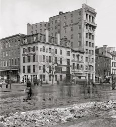 Washington, D.C., in a circa 1916 time exposure. "Corner of 7th and F northwest." National Photo Company Collection glass negative, 8x10 inches. View full size.
Police SwordsI find it fascinating that the policeman is carrying what appears to be a sword.
[That's a nightstick. - Dave]
Unassailable SupremacyHorn the Tailor was a bit like the Crazy Eddie  of his time: insane deals, high volume, lots of advertisement.  



F and Seventh TodayWent from a White Barber to the Verizon Center..
View Larger Map
Still ThereIt appears the Barrister Building is still standing, albeit with a set of large bay windows installed on the lower floors. The buildings on the far right also appear largely intact.
[This is looking down Seventh, not F. Welcome to Shorpy! - Dave]
View Larger Map
High Style on a Narrow LotThe Barrister Building is packing a lot of Renaissance style grandeur as well as height onto a single narrow lot. If I'm scaling this correctly as I look at it, it appears that the lot is an urban standard width of 25 front feet. Is that the case in Washington? Two of the upper floors also appear to be vacant, with For Rent or For Lease signs, causing me to wonder if this is a construction completion record photo. Is the date of this building known?
[It was built around 1910. - Dave]
Barrister BuildingI love the juxtaposition of architectural styles here: Colonial, Second Empire, Victorian and Romanesque.  Dave seems to be having quite a fixation with Mansard rooflines this week.



Office Structure Begun
Foundations are Laid for the Barrister Building

Foundations for another nine-story office building for Washington are being laid at 635 F street northwest, and within the next week or two the public will be able to obtain a general idea as to how large the structure will be when it is completed.  the building will be called the Barrister building, and will be a modern, fireproof structure, with a 29 foot frontage and depth of 120 feet.
The plans call for two electric elevators and an interior arrangement of offices, single and in suites, of from two to six rooms.  The furnishings will be in cherry and mahogany, with all the other appointments in keeping, and such as will constitute this an up-to-date structure in every respect.
the front of this first story will be of marble.  a light brick, with terra cotta trimmings, will be used above the marble.
Appleton P. Clark, jr., the architect, has incorporated in them all the features which the modern office building must contain.  The structure will be erected by Charles J. Cassidy Company, and A.C. Houghton, of 623 F street northwest, will the the rental agency.  The Barrister building will be ready for occupancy in July.

Washington Post, Feb 13, 1910 


Barrister Building photographed in October 1970 as part of HABS project (Historical American Building Survey)



Oops!That should serve as a helpful reminder to double check street names.
And thank you for the welcome despite my mistake.  I've posted here before but for some reason I never created an account.
Dirty SnowI'm deriving a certain amount of comfort in the realization that the dirty, slushy snow pushed to the curb is the same throughout the centuries. It's nice to know that some things never change. I'm also appreciating that handsome shoeshine stand at the corner, too. It was thoughtful of its attendant to stand aside when the photo was taken so that we'd get a clearer look at it. Those cornucopias hanging from the top of the Barrister Building are a nice touch as well.
The fleetingness of lifeEvery time I look at this picture I never fail to be reminded of that famous passage in The Tempest:--
Our revels now are ended. These our actors,
As I foretold you, were all spirits and
Are melted into air, into thin air:
And, like the baseless fabric of this vision,
The cloud-capp'd towers, the gorgeous palaces,
The solemn temples, the great globe itself,
Yea, all which it inherit, shall dissolve
And, like this insubstantial pageant faded,
Leave not a rack behind. We are such stuff
As dreams are made on, and our little life
Is rounded with a sleep.
(The Gallery, D.C., Natl Photo)