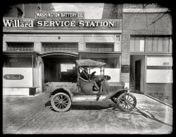 Washington, D.C., circa 1919. "Washington Battery Co., L Street." We saw the garage earlier in this post. National Photo Co. glass negative. View full size.
Before the Insurance ExcuseThey asked politely that you not talk to the guy who's actually working on your car.
Big Sign ShopZooming in we see the name of the business that made the sign. Like it.
Pick Me UpIs this the ancestor of all pickup trucks?
Also:  note the sign.  No talking to the mechanics.
Hard Four Years CrankingSuper is offering a lift in his 1915 Ford Model T Runabout. No starter motors on this model. He hand cranks it and then gets in. 
Rear deck and bulb type horn have been replaced with aftermarket pickup bed and manual horn. Practical pickup style not offered by Ford until 1925.
The BIG SIGN SHOP, Inc.On my best day I couldn't photograph something like this and get the clarity that it shown in this photo.
Brought to mindThis vehicle reminded me of the plastic model car kits my brother and I used to put together in the late forties, very early fifties during long summer days with no school.  They were usually (very) antique old-time cars which we could not conceive of being road-worthy, which we had never seen and which we usually messed up due to the plastic cement which dissolved the plastic and the enamel paint which was  difficult to apply neatly.  Also each and every little part had to be attached, sometimes with a heated metal object to secure wheels, spokes, etc.  The kits were sold in dime stores for a dollar or less.  Just for the halibut, I decided a minute ago to look them up on the interweb.  There are no more $1 car models, more like $20 and up, and the ones we had are long gone.  I first heard about Stanley Steamers and Model T Fords via those plastic do-it-yourself car models.  Remember plastic bubbles and magic growing rocks?  All kinds of cheap crap to keep the kids busy in the summer.  Good times.
Such a spindly little thingIt's the scrawny 98 pound weakling of pickup trucks, compared to the 2-ton behemoths of today. 
Pick Em Up TruckI can't get past the sign with the words "any information desired will be cheerfully given". As if you would expect to get info delivered in a grouchy manner.
Buying a car?This reminds me of the last time a dealer sold me a car. He insisted that the car he was selling me is a demo and nothing was wrong with it. After having problems with the car he sold me I went to his workmen and asked them for a computer printout and sure enough the car was in a major accident!  "We Respectfully request costumers to refrain from talking to workmen any information desired will be cheerfully  given by floor superintendent."
[That Bob Mackie was kind of a blabbermouth. - Dave]
Highway PioneersMy first modeling experience was building some of the styrene Highway Pioneers models made by Revell.  I built a bunch of them and had a lot of fun in the process.  They were not terribly durable, at least in my young hands, but I loved them nevertheless.  The distinctive feature that I remember, like OTY describes, was the way the wheels were attached.  You were supposed to heat a slot screwdriver tip over a flame, and use it to melt the end of the axle.  This formed a tip at the end like a nailhead that kept the wheel on.  It was clever, by you had to be careful not to melt the axle into the wheel.  No two hubs ever looked quite the same, but it worked.
(The Gallery, Cars, Trucks, Buses, D.C., Natl Photo)