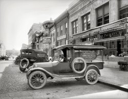 Washington, D.C., 1919. "Automobile with ad for Oppenheimer's shop, 800 E Street N.W." Faintly visible in the distance on the left is a large sign for the Center Market. National Photo Company Collection glass negative. View full size.
8th Street NWApparently, Oppenheimer's had more than one location.  The address on the truck clearly notes "800 E Street, N.W." but this view (with "Oppenheimer's" noted on the storefront) is looking south from the 400 block of 8th Street NW (toward what was the Center Market as Dave noted and is now the National Archives).  Looks like I might have to take "+91" tomorrow if I can get out of my office for a few minutes.
Update: Dangit!  I just realized that it was a corner building and had to log on to update my post, but an Anonymous Tipster pointed it out first.
View Larger Map
800 EThe photo does indeed show the Oppenheimer's at 800 E Street. It was on the corner with facades on both 8th and E Street, which is just behind the camera.
Ribbosene Silk: For Sweater Knitting

Advertisement, 1918 


Oppenheimer's
8th and E Sts.
Headquarters for Sewing and Knitting Needs.

Plaiting, In All Its Branches: Embroidery, Initialing, Braiding, Hemstitching, Beading, Picot Edges.
Fringes: All the vogue for waist, dress and gown trimming.  We make them to order in any color you want.
Buttons: Pearl, Fancy and Cloth, in All Shapes and Sizes.  Buttons to Order to Match our Garments.
Ribbosene Silk: For Sweater Knitting.  We Carry in Stock All the Pretty Colors.
Yarn and Wool: Our stock is always complete.
Dress Forms: Dressmaking is a simple pastime if you have a good dress form to make your dresses, waists or gowns over.  We have all styles at popular prices.
Sewing Machines: Singer, New Home and other makes. Always bargains to be had here in sewing machines.

Sold on Easy Payments.
Oppenheimer's
Shop Unique
Cor. 8th and E Sts. N.W.




For a buck an hourCan you figure out what's making that funny noise under the hood?  And go ahead and burn out the carbon while you're at it.
Oh wait, I'm fuel injected now.
The truckDodge Brothers commercial screenside, a sort of van-pickup hybrid that was popular until the 1930s.
+91Below is the view from September of 2010.
(The Gallery, Cars, Trucks, Buses, D.C., Natl Photo, Stores & Markets)