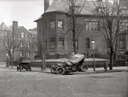 "Auto wreck, Mass. Ave., Washington circa 1917." A comment on our earlier post of this accident correctly pegged the location as Massachusetts Avenue at 21st Street N.W. National Photo Company Collection glass negative. View full size.
Religious Action CenterAlthough the idea of a Baptist night club is pretty delightful, kinda like Amish Karaoke Night, it's not really that kind of "action." The Arthur and Sara Jo Kobacker Building, 2027 Massachusetts Avenue NW at Kivie Kaplan Way, is home to the Religious Action Center of Reform Judaism, a lobbying organization.
Where&#039;s the Crowd?I think this is the first accident photo I've seen on Shorpy where there isn't a group of people standing around looking at the wreck or the photographer.
Darn it!Dave, you stole what was going to be my comment with the title of the post!  Only 26 cars in DC, and two are right here.
The real question is what car or other large moving object hit #26, as it appears that #24 is just pulled to the curb parked.
Psychic Midget!The kid obviously crushed the vehicle with her telekinetic powers. It's always the midget!
24Seems to have a tiller instead of a steering wheel.
AhhhhWith this photo, we now have the complete scenario:
A. The vehicle was parked at the curb when it was struck. (Evidence the parking brake is set, photo 1.)
B. The rope had secured the vehicle to the lamp post.  (DC had a vehicle theft problem since the Jefferson buggy incident of 1803.) 
C. I am so full of it.  
WindowsThe most interesting thing about this picture is the exterior Venetian blinds on the corner house.
Someone needs to print this pictureAnd deliver it to the owners of the current address.  I sure wish someone would hand me a picture of my 1918 house when it was relatively new...
JazzDadI'm getting the idea, JazzDad.
Ever since I found Shorpy, I've been wanting to post one of those definitive, plonking replies, such as:
"That's Luna Park at Coney Island.  The big fish sculptures at the base of the tower are the giveaway" or
"Has to be a B-17E, look at the dorsal fin and the framed nose transparency"
Someone always beats me to it.  But thanks to your post, I can see whole new fields of commentary opening up......
Crash Investigationon closer inpection of the photo reveal debris from the wrecked car in the middle of the street. it was probably dragged fron there to the sidewalk.
I'm amused by these photos of early century DC auto wrecks. with so few cars on the road, how did they ever find each other, then run into each other?  
First. . . for the obligatory streetview:
View Larger Map
What is that building?Someone else beat me to the Street View, but I looked alongside the building, and it is quite long.  Was it a dorm, or boardinghouse, or something?  
I see nowThanks for the enlargement. Danged trifocals!
If this were a horror movie, this might be the time someone says:  "I wonder who they're trying to keep out?"
Then the sidekick would say: "Or keep ... in!"
Tin Door?Interesting building in the background.  Why do you suppose they blocked off the doorway with sheets of corrugated tin?
[Those are boards, and there's still a door. It is unusual. - Dave]

It got better with ageFinally, a building that looks better today than it did 90 years ago!  If you look at the back of it on Street View, it's got the oddest collection of mismatched windows.  I'm with Gus Oltz: would some Washingtonian please tell us what the heck this place is?  (Bonus points if you can provide interior views.)
[It's the "Religious Action Center." Some sort of Baptist night club, maybe. - Dave]
View Larger Map
Behind the barsIt appears that there are bricks a few inches behind the bars which doesn't make sense unless it was done for decorative purposes.  Perhaps to offset the horse-barn look of the front door.  Y'all are right.  The house is becoming more interesting than the accident.
[I don't think those are bricks. - Dave]

Windows TooI too am intrigued at the exterior blinds on the house.
I wonder if anybody was ticketed.
BarredActually, I thought it interesting to see that "security bars" were necessary at such an early date (building, right). I guess I'm kind of amused at my naivete ~ city life being what it has always been.
Skid MarksLooks like the skid marks tell the tale.  
Accident ReconstructionThanks to the Accident Analysis Center, one of the most important research firms and reconstruction of road accidents in Spain, made an enlightening video that answers the question "What really happened?"
http://www.elzo-meridianos.blogspot.com/
[All I can say is, "Wow!" (En Español: ¡Wow!) - Dave]
Re: Accident ReconstructionOMG! This raises the caliber of Shorpy comments to an entirely new level. ¡Me encanta!  
I am still bothered by that rope, however.  I think that rope is there because it was used to pull the stricken vehicle out of the intersection.  Thus, the photographed resting place of this car shouldn't be assumed to be the direct result of the collision.  (Perhaps this is idea is already incorporated in the "Accident Reconstruction." Por desgracia, my Spanish is not good enough to tell.  Perhaps we could be blessed with an English version of this video for all us poor (ugly) Americans who only studied foreign languages in junior high school.)
Reconstrucción de accidentesFor the benefit of fellow English-speaking visitors, I've made a translation of the texts included in the fantastic accident reconstruction video posted here. Hope this can make the magnificent video easier to understand.
-.-.-
Found at www.elzo-meridianos.blogspot.com
A 100-year-old traffic accident.
It’s always amusing to see old pictures. By looking at these 1917 photographs it looks like we haven’t improved at all. An almost daily picture, where we see we have hardly learned anything. On it you can see a wrecked car on the curbside at Massachusetts Avenue in Washington, D.C. It was the longest street in the Capital, formerly known as Millionaire’s Row, now Embassy Row.
It’s impressive to see the massive damage, seeing a lonely child watching the wrecked car. You can see the broken wooden spokes of the destroyed wheels. The license numbers of the vehicles involved in the crash are perfectly clear: numbers 26 and 24. Many questions arise when we see these amazing pictures; what actually happened here?
What actually happened?
Warning
The information in the following video DOES NOT correspond to a rigorous case study. We don’t have the necessary and mandatory starting point data for any serious traffic accident investigation (conditions of traffic, measurements, forensic analysis of the vehicles, etc.)
The following video only offers an appreciation based on the photographs and developed by sheer fun.
Center for the Analysis of Accidents
Investigation and Research of Traffic Accidents
-.-.-
EXHIBITS
Exhibit A: Impact point
Exhibit B: Skid marks (left wheels)
Exhibit C: Skid marks (right wheels, less visible)
A priori, the vehicle parked at the curbside with license number 24, does not seem to be involved in the accident. There is no appreciable damage or deformations, not even on the front of the vehicle. There are not spilled liquids under it, nor any apparent evidence that could imply it had any part in the accident.
It only has the top pulled to the back without folding; that way it took less time to put it on place in case of rain. Had it been involved in the crash, the front of the car should show appreciable damage, even from the point where this photo was taken. The stick protruding from the left is the steering cane, a forerunner of today’s steering wheels.
Possible mechanics of the accident
The car on the photograph (represented in red in the reconstruction) could be driving on 21 St due North, with the intention of either continuing on the same direction or turning right on the intersection.
Another vehicle (represented on blue) was driving on Massachusetts Avenue, due west.
When it reached the intersection, the car of the photo, either due to loss of control or because of a mechanical problem, or because the driver tried to make the turn at an excessive speed, starts to skid to the right.
It leaves skid marks in the shape of a fan. The marks made by the left-side wheels are darker than those from the right-side wheels, because the left wheels were exerting more friction.
An impact is produced, of the type frontal – lateral, damaging mainly the rear-left section of the car. The rear wheels could break at this moment as a result of the impact, since they were bent on an opposite direction from the movement of the car with which the vehicle crashed.
Washington, D.C., 1917.
Massachusetts Avenue
21st Street
It is unlikely that the position on which the car was photographed was its authentic final position after the accident. Probably it was towed away to the curbside so that it wouldn’t obstruct the traffic on the street.
In order to move the car, they could have used the rope that appears to be tied to the rear of the car, with the other end of the rope left in the interior of the vehicle after the maneuver.
It is possible that the car was moved to this location in order to allow the leaking fuel to fall to the sewer, in an attempt to prevent possible accidental fires; who knows what policies or procedures followed the towing services back then?
Wow!Unbelievably cool reconstruction of the accident!
(The Gallery, Cars, Trucks, Buses, D.C., Kids, Natl Photo)