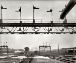 Washington, D.C., circa 1920s. "Union Station signals and tracks." National Photo Company Collection glass negative, Library of Congress. View full size.
Riding on the MetroI ride by here daily on the Metro. I believe this is facing west [it's north-northeast - Dave]. The landmark that stands out is the switching house, which is still there, and in the photo is at the lower middle slightly to the left.  If I have my orientation, right, the Metro Red Line goes by on the left, where you can kind of see a train in the photo.  This would be facing with your back to Union Station.
When I see the switching house, it looks like it's 100 years old.  It's green-copper stained with some gray.  Most of those tracks are still there, and there's now also some old electric train wires hanging overhead which may date back to the 50s (I am not sure).
Some things never change.I work for the Long Island RR, and it seems that very little changes in train yards. The equiptment changes with the times but not much else. It's definitely a bit of a throwback occupation.
K TowerThis is a fantastic photo of the place I have worked since 1990 - K Tower, Washington Terminal. It controls all of the former Washington Terminal signaled trackage. Semaphore signals were replaced in the 1950's with color position signals.
Richard Hafer
K Tower Train Director
(The Gallery, D.C., Natl Photo, Railroads)