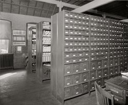 Another look at the operations of the Chesapeake &amp; Potomac Telephone Co. in Washington circa 1925. National Photo Co. glass negative. View full size.
FilesMan, I'd love to have a set of those file cabinets. They'd be great to keep my craft stuff in. 
ShelvedCreaking floorboards and perilous shelves--how wonderful--just like Foyle's bookstore in London. 
(The Gallery, D.C., Natl Photo)