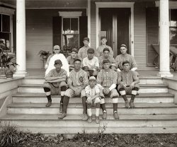 Washington, D.C., circa 1926. "Modoc baseball team." Who seem to have been a rather short-lived club. National Photo Co. glass negative. View full size.
Baseball IQsHave you ever noticed that baseball players look the least mentally gifted of almost all athletes?
FloppyThe fellow on the left resembles "Shoeless" Joe Jackson (also featured in the above post). Floppy ears and all. Obviously it's not him, but they sorta do bear a likeness. Either that or John Sayles.
Come Fly With MeHalf these boys look like they'd take off in a headwind. Jughead on the left there must be at least a little special to have been dropped out like that.

White-OutDid you white-out the background behind the young fellow pictured above?  Or has he suddenly sprouted angel wings? By the way, I think the younger boy in front is his little brother.
[Not me! The background has been blacked out on the negative, probably with ink. The opposite of what we see in the positive image. - Dave]
I&#039;d go with the &quot;angel wings&quot;The team was understandably morose when they posed for this picture, only two weeks after teammate "Mac" had been killed by a runaway trolley car.
But lo and behold, when the photo was developed, there he was, sitting with them!
RelationsThe ears suggest a few blood relations amongst these players.
Tenleytown teamFrom Washington Post, March 29,1926 p. 15
"Red Eagles Triumph
The Red Eagles showed the heavier hitting in a slugfest game against the Modoc baseball team yesterday, and triumphed 9 to 7 at the Tenleytown diamond."
and from Washington Post, May 8, 1927, p. 26
"The Modoc baseball team wants an unlimited game for today. Call Manager J. Gilbert Markham at Cleveland 4828 if interested."
Images of both clippings available if someone wants them.
So the house has a street number of 5118 (see both columns), the Cleveland exchange at that time covered the Tenleytown and Cleveland Park neighborhood. If that house still exists, it's on a north south street. There's no 5100 block on an east west street up there.
Carefully BlockingWhat in the world would have caused such careful blocking out? Of what? It couldn't be a person, given the seating arrangement of the other guys. And yet the blocking was done so carefully. Another mystery on Shorpy!
[The background was inked out to get this standalone photo ("mug shot") of the kid. - Dave]

(D.C., Natl Photo, Sports)