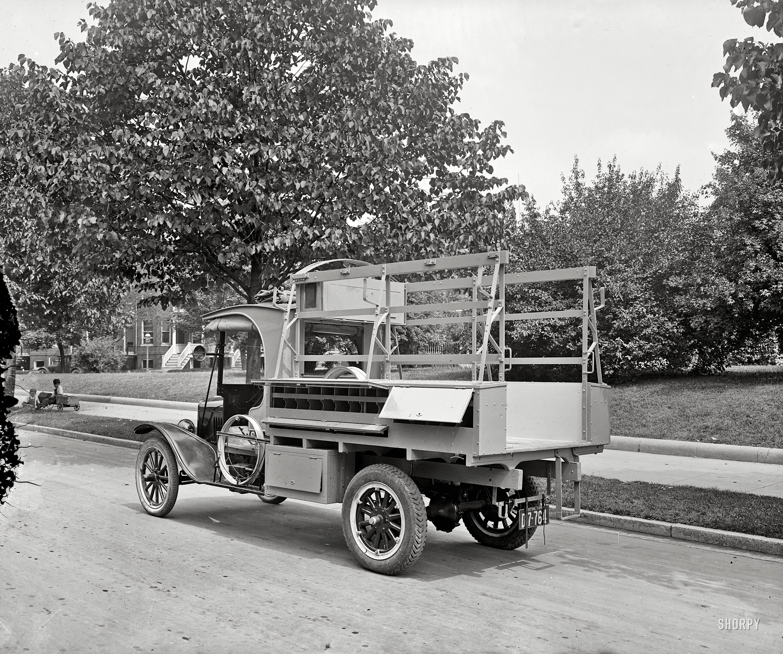 Washington, D.C., circa 1925. "Caption torn off [truck with cabinet compartments]." The creeping crud that has obliterated the label on this glass negative is about to gobble up those youngsters on the sidewalk. View full size.
