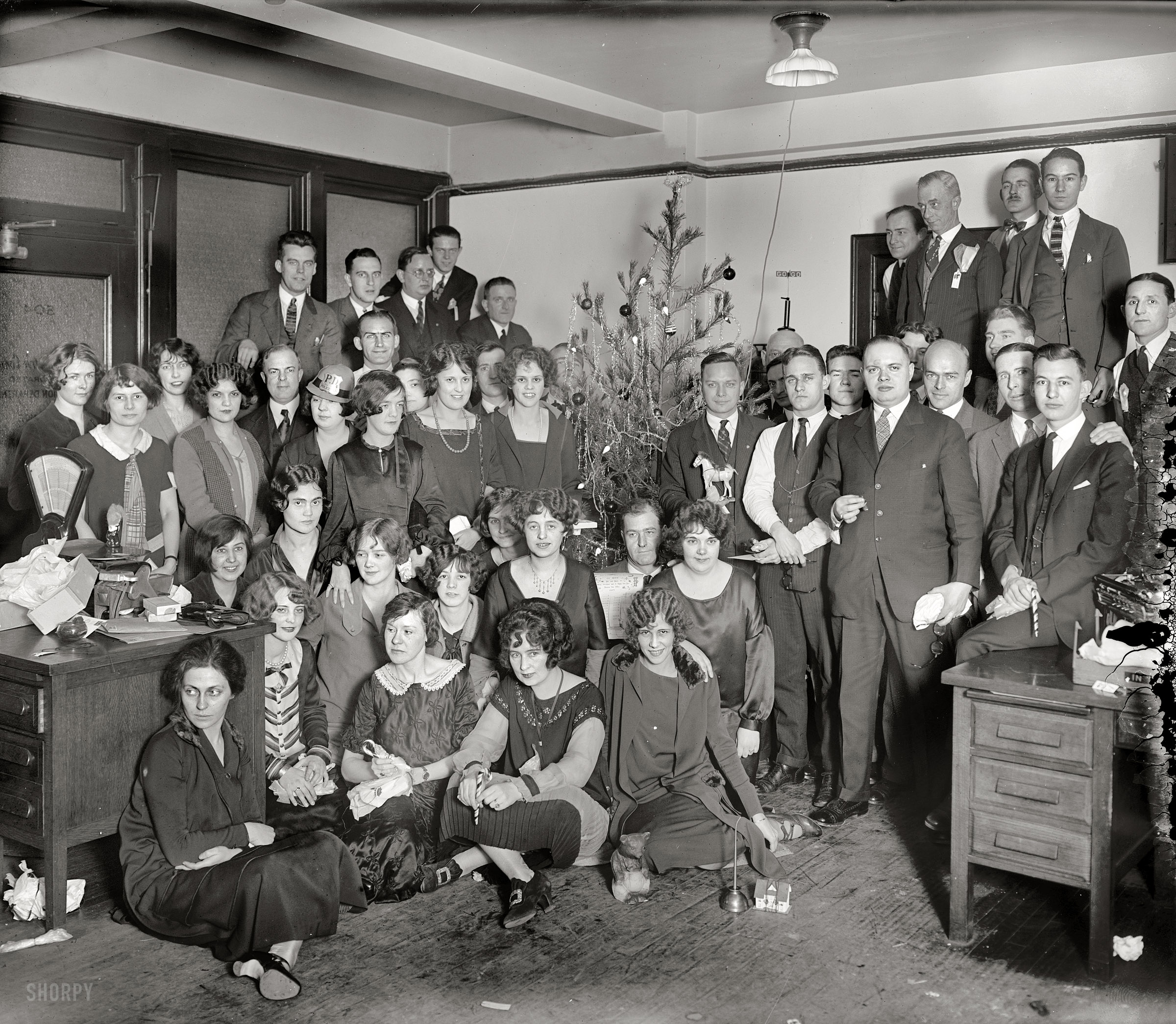&nbsp; &nbsp; &nbsp; &nbsp; It's the week before Christmas, time for a hallowed holiday tradition here at Shorpy: The Office Xmas Party! Which has been going on for 97 years now. Will Clarence in Sales ever get up the nerve to ask out Hermione from Accounting? Is there gin in that oilcan? Ask the bear.
December 1925. "Washington, D.C. -- Western Electric Co. group." There are enough little dramas playing out here to keep the forensic partyologists busy until Groundhog Day. National Photo Company Collection glass negative. View full size.