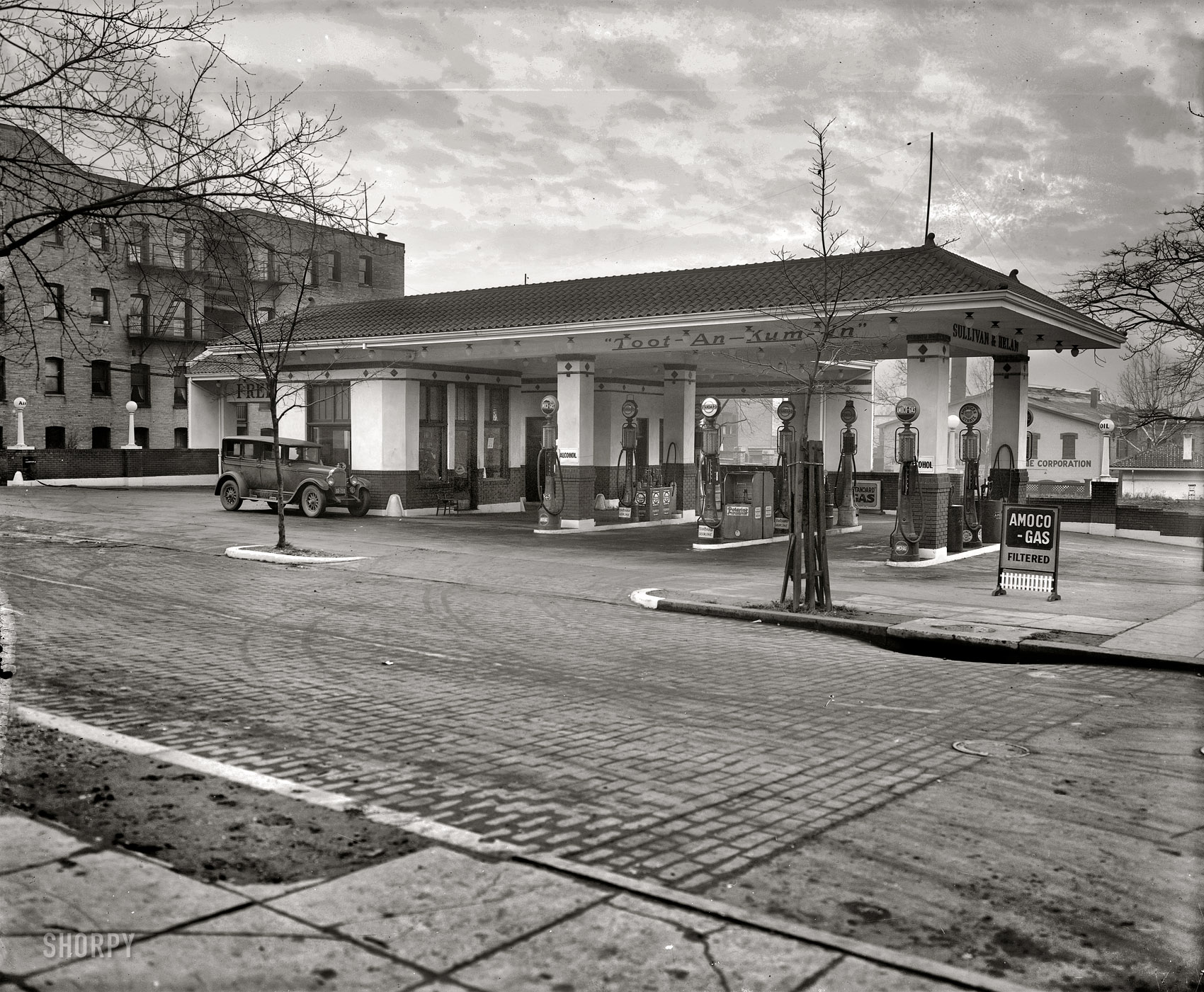 "Texaco Co., Sullivan & Helan station." This Amoco station at 14th and Belmont streets N.W. in Washington's Mount Pleasant neighborhood opened in July 1925. After the discovery of King Tut's tomb, the vogue for all things Egyptian extended even to gas stations. National Photo Company glass negative. View full size.