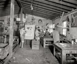 Rosslyn, Virginia, 1926. "Walling Process Inc." A graphics business owned by one George Walling. National Photo Co. Collection glass negative. View full size.
Frappucino, anyone?The two most interesting pieces (to me) are obscured so I can't see them. The man peeking out from the left pillar (FATI____) and the two images of power lines with words underneath. 
Also on the left appears to be an ad for "ice coffee" - I don't know why, but I've always thought of this as more of a modern thing. I'd love a frozen coffee right now, but I think the men of Walling Process are years away from the first Slurpee machine.

Safe Money7% First Mortgage Bonds.
No loss to any investor in 53 years.
How times have changed!
I bet all that sticky ink got all over their shoes and cuffs despite the overalls.
AmazingSuch tedious detail and intense (and messy) work.  83 years later all this is done by one person, in a fraction of the time, with superior results, in a spotless environment with a computer and printer.
... MAThe man with FATI over his head is an ad for Fatima cigarettes. A saying current in 1918 was "Ashes to Ashes / Dust to Dust / if the Camel's don't get you / the Fatimas must"
SpellingApparently, spelling wasn't foremost with the folks at Forst's Formost Hams or it wasn't foremost in the Walling Process.
Art DecoThis is a wonderful array of (now) vintage Art Deco posters. I wonder what they'd go for on ebay...
ColorIf ever there was a Shorpy picture I want to see in color, this is it. Who's up for colorizing? Just the artwork in color alone would be interesting to see.
(Though it wouldn't be as interesting as I first thought; initially I thought the floor was covered with spattered paint before I realized there was mold damage to the emulsion.)
Looks like funbut I think I'd prefer Adobe Illustrator.
Senses TinglingCheck out that web at top. Jeepers!
It is also fascinating to see these images created by hand rather than the current digital process. Incredibly artistic endeavor.
Flowers From HitlerDid Adolf pose for a poster when he was in art school?  That sure looks like him in the poster the Mike White -looking guy is holding.  
Walling ProcessIn the graphics industry, "process" indicates silkscreen ("screen process") printing.
Lyon Village, advertised in the sign just above the artist's head, is still there. It's a lovely community almost completely shaded by trees, but it's not a suburb anymore. It's right in the heart of Arlington, Virginia (just a bit off an arterial road) just a couple of blocks from the edge of the high-rise office towers that have spread out from Rosslyn.
A great studio view!As an illustrator, I can't tell you how wonderful it is to be able to get a peek into a period   studio in such detail. This appears to be a graphic ad studio specializing in silk screening. The guy on the right is pulling the ink over the screen. The others look like they are posing with proofs. I doubt the guy at the easel has even a drop of paint or ink on that brush, but maybe he is touching it up for presentation to the client.
This is from an era of silk screened posters as art, and it would continue into into the 30s  with wonderful WPA prints being made this very way. Too bad  this kind of commercial art is a thing of the past. 
I find it amusing that the artists are wearing the proverbial "smocks" over their shirts and ties, and pleated pants. Not the way I go to the studio!
If only more pictures like this existed. There are now whole magazines dedicated to giving readers glimpses into artists' working places. Imagine an entire book of period studios like this!
Good art, sloppy shopSo many of the workshops we see on Shorpy are a mess. Cobwebs, thick dust, scraps of cloth, buckets of paint and turps, and what looks like a cigarette butt on the table in the right foreground. 
When I was in the screen printing business I learned that ink travels to wherever you do not want it.
The mystery poster may be for Fatima cigarettes; if I had this and the other posters we see here I would have a tidy sum in my retirement account.
Color me impressedWhat a fabulous photo! It's strange to see such clean, sharp Art Deco pieces in such a filthy surrounding. On full view, the giant cobweb at the top was the first thing I noticed.
I only wish I could purchase that beautiful "Christmas festival" poster on the far left.
Lyon Villageis just a few short miles away from the sign shop, between Wilson Boulevard and Lee Highway in Arlington. My first residence in Arlington (1964) was the Cardinal House Apartments, across the street from the Lyon Village Community Center. Lyon Village today is a beautiful and very desirable neighborhood, just as it must have been in the 1920s.
Not so Safe MoneyThe first Google search that comes up for F.H. Smith is a reference to its chairman and seven board members being indicted for mail fraud in 1930.  
I guess some things haven't changed too much in ~80 years.
Another one...I'm also a commercial artist. I've done a lot of art for T-shirts that get silk screened. Totally different than the traditional methods shown here, though. I do a full colour painting that gets photographed, Photoshopped and then silk screened in full four(or more) colours on the shirts.
Like JohansenNewman, I love seeing period shots -- that place looks just like an art studio should! And Johansen -- What? You don't wear a tie to work in your studio? Well okay, I don't either, but I've sure ruined many an item of clothing due to my extreme sloppiness while working.
Carpal Tunnel Syndrome and Lead-Based InksTwo of the major hazards to which these gents were exposed every day. Pulling a huge squeegee repeatedly is murder on the wrists and hands. Ergonomically-designed squeegees didn't appear until the nineties. 
Walk into any busy screenprint studio and the stench of the chemicals is overpowering. "The smell? Oh, you get so you don't even notice it."  
And, I hate to be a  nitpicker but...I don't believe that any of this work is actually Art Deco. It's a bit too early for that. The movement really only began in 1925 in France and was unlikely to have filtered down to graphic shops on this side of the pond. Whatever it is, it has the sinuousness of Art Nouveau but I don't know if they still called it that in the twenties.
www.Before you were on the web you worked underneath it.
The processI'm not sure what Ray, in his comment "Amazing" below, means by "superior results," but I think the case can be made that the golden age of graphic design and illustration ran from roughly about 1900 to 1960. In the long process of learning and mastering the then-complicated techniques involved in producing the finished result, usually under the mentorship of experienced craftsmen, one also absorbed the fundamental principles of design. The techniques are certainly easier and faster these days, but pointing, clicking and dragging alone aren't enough to produce good design. Look at the average web site. 
&quot;Misuse of dairy bottles&quot;Dairies used to complain somewhat that they were losing money when customers found other uses for their milk bottles instead of returning them. I see two here that won't be going back to be refilled. 
Cell phones and digital artThanks for giving some insight to those two posters! 16 millon telephones, eh?? Today there are almost 3 billion cellphones!
I'd question the "Amazing" commenter. The process is different, but I don't think today's artwork is necessarily created "in a fraction of the time" or "with superior results." Both could go either way: digital art is not necessarily quicker, and you could argue either version's superiority.
(The Gallery, Natl Photo)