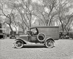 Washington, D.C., 1926. "Semmes Motor Co. National City Dairy truck." A dented Dodge. National Photo Company Collection glass negative. View full size.
Looking along 8th StreetWith the Old Patent Office (now the National Portrait Gallery) at Eighth &amp; F Streets NW in the background.  
[It could also be the identical north facade at Eighth and G but I think you're right, as this photo seems to have been taken near the Center Market at Eighth and Pennsylvania. Kudos for correctly identifying the building as the Patent Office and not the Treasury. - Dave]
Sleek, manApart from the damaged fender, this vehicle has a sleek look accentuated further by that spare tire.  Fabulous material for a hot rod in later years.
The ViewYes, Odie is right. I'm sitting a couple of blocks from there right now. The building you can see behind the truck, through the trees, is the old Kann's department store on Pennsylvania Avenue between Seventh and Eighth streets.  
(The Gallery, Cars, Trucks, Buses, D.C., Natl Photo)