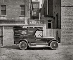 1926. "Semmes Motor Co., Schrafft's truck." A Dodge truck in Big 4 Candy livery at 608 E Street N.W., Washington. National Photo glass negative. View full size.
Brick BondsThis side of the Atlantic, this pattern is usually referred to as "Common Bond" or "American Bond." The vast majority of 1800s brick buildings in Washington (including my house) use this bond.
Scottish Bond Alert!The brick laying pattern is Scottish Bond: five layers of "stretchers" - or, long brick and one layer of "header" - or, the end of the brick. I would never have known about this if I had never browsed the archives here. Who says that this site isn't educational? For the remainder of my life I'll be noticing brick patterns - something I have never given a moments thought to before. A tip 'o' the hat to the commenter who first brought this to my attention in a photograph taken behind a Civil War hospital. 
What&#039;s in a name?As a retired graphic designer in corporate marketing, I am always intrigued by trade names and visual treatments. The name is spelled out on the truck - but with a numeral 4 logo treatment for the text to wrap around - yet the sign over the entrance only employs the numeral (definitely not a space issue there). Being a wholesaler, the name has no need to appeal to the consumer, but does it refer to the number of owners, categories of confections, or is it merely arcane? The sign painter knew a thing or two about compressing (condensing) fonts to fit the space and enhance the flow (note "wholesale" as opposed to "confectioners"); this was a common period design feature that began in Victorian graphics but was soon to disappear from the scene as advertising typography became more austere as images began to carry the message between the great wars.
Nice hanging gate to the alley/courtyard -- and no using both entrances at the same time! The fence to the right uses whatever board width came to hand.
(The Gallery, Cars, Trucks, Buses, D.C., Natl Photo)