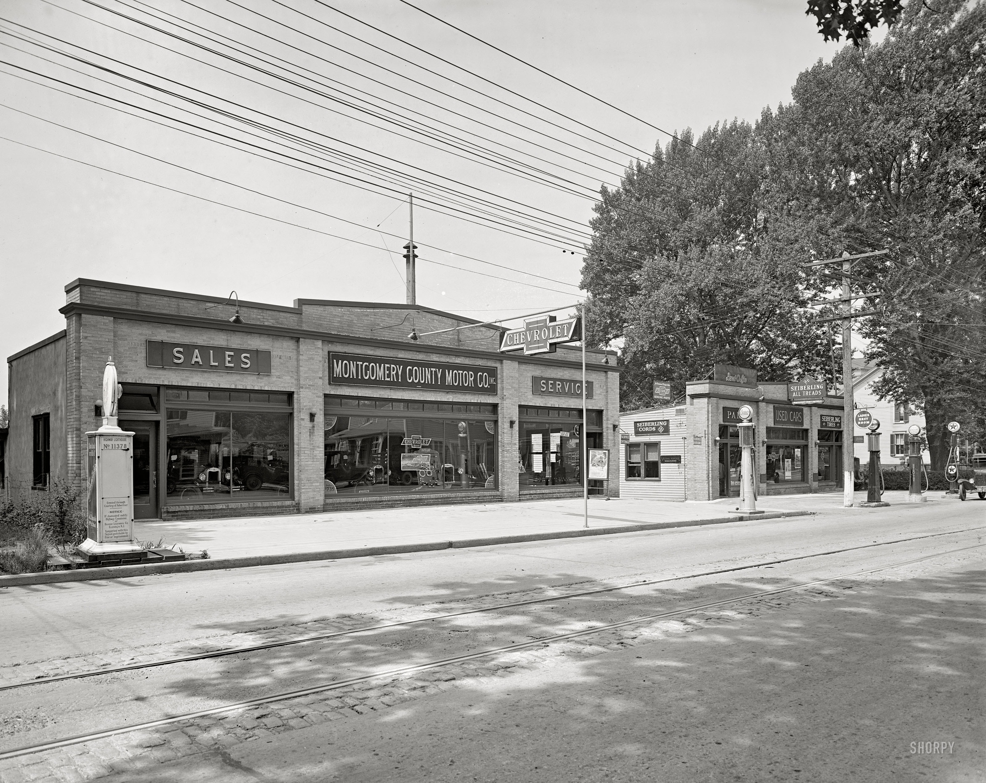 Rockville, Maryland, circa 1926. "Montgomery County Motor Co." What caught my eye is the "Highway Lighthouse" on the left, emblazoned with an ad for Studebakers. National Photo Company Collection glass negative. View full size.