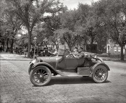 "Semmes Motor Co." Washington, D.C., Fire Department car (a Dodge) circa 1926. View full size. National Photo Company Collection glass negative.
No. 8 EngineHey Dave, could you give us a close-up on that street sign?  It looks to my eyes like "No. 8 Engine" but hard to be sure.
Thanks!  No. 8 Engine Company, founded ca. 1889, was located at 637 North Carolina Ave. SE, adjacent to Eastern Market.  The company used horse-drawn equipment until June 1925, so this photo would have been soon after the controversial (What if the motor doesn't start?!) conversion to motorized transport.

Charming BlockWhat a charming block of fine old homes with iron fences and plenty of shady trees.  I hope it's still intact.

The D.C. Fire Dept. Dodge inThe D.C. Fire Dept. Dodge in the foreground appears to be a circa 1916 - 1923 model.  The lack of any hood louvers is the clue to these early Dodge models along with the hubcaps.
The D.C.F.D. Fire Marshall car behind it looks like a circa 1918 Buick.
The fire truck is a Seagrave pumper circa 1921 - 1926.  This truck has the wider grill and hood that was introduced in 1921.  Note also the intricate grapic on the side of the raised hood between the two sets of hood louvers.  Could that be George Washington in the center?  Many fire departments used this space to place some design, company letter, or engine number.
The lack of any fire, smoke, water, damage, or firemen in action (outside of those in the cars and the possible exception of the guy leaning against the tree) makes me wonder what is happening here.  The hose coming out of the fire truck to the curb in front of the fire marshall's car is pretty short and does not look like it has any water in it at all (it looks flat).
Every day at workZcarstvnz. Please note the other comments. The buggy is on Eng 8's apron . The fire engine that's hooked up to the hydrant is testing hose or drilling. No fire. 
Chief&#039;s BuggiesThe cars used by Chiefs in the DC Fire Department have always been called "Buggies". Still are.
(The Gallery, Cars, Trucks, Buses, D.C., Natl Photo)