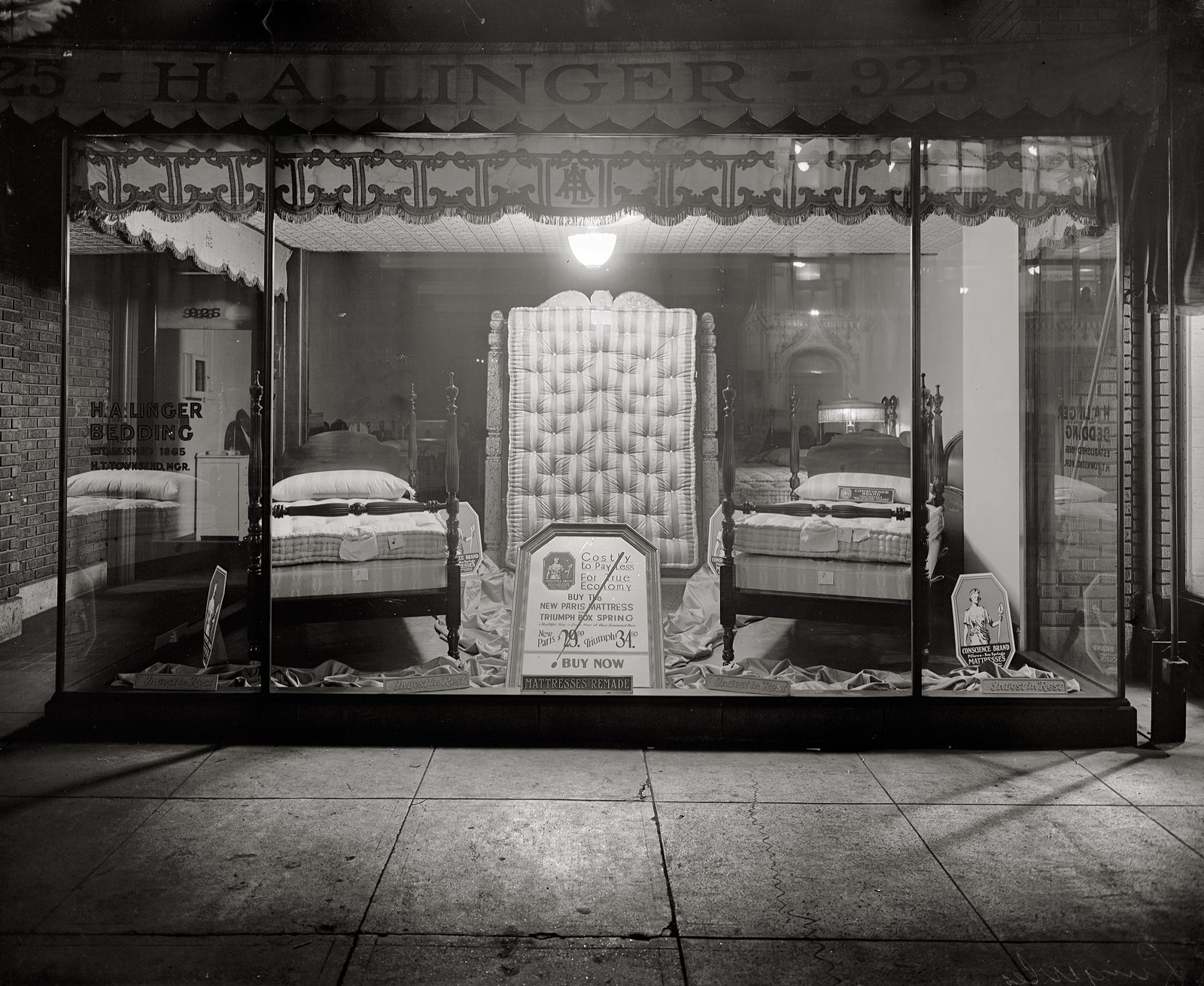 Washington circa 1925. "H.A. Linger window." Here we have a display for a brand of mattress called Conscience. Conscience wears a blindfold and carries a torch. ("Go ahead. Even if he loved me more. Live it up! I'll never tell. But you'll always know what you did.") Yes, it's the mattress for people who are always being asked how do they sleep at night. National Photo Co. glass negative. View full size.