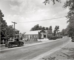 Silver Spring, Maryland, circa 1927. One of three National Photo glass negatives with the caption "Jordan &amp; Co." National Photo Company. View full size.
Nothing LeftAccording to Jerry McCoy's "Historic Silver Spring" (which has this photo), this is the west side of Georgia Avenue at Harden Street (now Wayne Avenue). All modern office buildings now.
Film SpeedA day-time photo in the 20's still with a slow shutter speed? I would have thought by this point that the film would have been fast enough to stop the action. Just what film speed were they using in those days?
[They weren't using film. As noted in the caption, this scene was recorded on glass. - Dave]
Love Silver SpringIt lasted until at least 1970 and by 1980 it was mostly gone.
historicalaerials.com shows how it used to hardly be an intersection at all!
Jelly Roll Morton and moreJazz pianist and composer Jelly Roll Morton used to talk about filling up his Cadillac with "that good Gulf gas," and I thought it a phrase he had made up -- now I know he was someone else who had fallen under the spell of a catchy slogan.  For me, the most evocative part of this delicious scene has to be the shadows of unseen trees, bottom right.  
http://www.jazzlives.wordpress.com
K of CThe building hosting the chicken dinner was the Knights of Columbus Hall, 8500 Georgia Ave.  Built circa 1926, it was sold in December 1930 and remodeled for use as a house of worship by the newly founded St. Michael's Parish. The congregation moved in 1952 to its present home at 805 Wayne avenue.
Windows and treesThis is just a wonderful photograph, catching a casual moment long gone.  I live in a house built in the mid-1920s, and its wood-framed windows are exactly the same as those along the side of the Knights of Columbus Hall.  There is a touch of modernity, yet not-so-modern in this photograph.  With the black and white detail, you can almost hear the dry breezes rustling through the branches of the trees.  A muted moment that is spectacular.  
Shutter speed.Glass plates and film had similar speeds.  The use of a slow shutter speed was due to the need to stop the lens down for depth-of-field, in other words a large area from foreground to background that the photographer wanted to keep sharp.  I shoot the same size film now, and I often use shutter speeds in the 1/4 to 1 second range in order to stop the lens down for maximum sharpness front to back in the scene being photographed.
Emulsion Speed in the &#039;20sIn the 1920s, photographic media weren't rated at standard speeds the way we do today. But if they were, their ISO numbers would generally fall in the 8 to 16 range, with a few "Super Speed" and "Ultra Speed" emulsions being as fast as ISO 32. The proper exposure in full sun, like this picture, with an ISO 16 emulsion, would require around 1/15 second at f/16. A large format camera, like those that used glass plates, would require at least f/16, if not a smaller aperture, to yield the depth of field seen here.
I pulled out my copy of "The Camera, the Photographic Journal of America" from June 1926 and reviewed the exposure info for some images and found that most exposures made on sunny days were longer than 1/15.
Sunny&#039;s SurplusI think the K of C building also housed Sunny's Surplus in the 60's.  There was a great old green-painted brick building across Georgia Avenue that housed a slot-car facility around the same time.
(The Gallery, Cars, Trucks, Buses, Natl Photo, Stores & Markets)