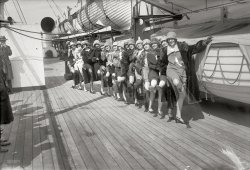 New York, 1926. "Tiller girls." Arriving from England, 16 chorus girls in the troupe originated by British musical-theater impresario and precision-dancing pioneer John Tiller. 5x7 glass negative, George Grantham Bain. View full size.
Titanic ProportionsThe ship in the photos is most likely the RMS Berengaria of the Cunard Line. She was originally the German ship Imperator and in 1913 had the distinction of being the first ship larger than the ill-fated Titanic to make her maiden voyage.
One of the reasons Titanic was shy of lifeboats was because they would block the view of the ocean. By 1913 the lesson was learned, and the boats here are stacked so tall they actually form a wall.
[Based on shipping news items in the New York Times, the boat seems to be either of the Cunard liners Carinthia or Samaria. - Dave]
Tiller girlsMy grandmother was in the Tiller girls, but 25 years earlier than this. She moved from Ireland to London as a teenager and got a job on the stage as a dancer. She met and married an older businessman. 
By 1926 her son was 19, and at sea in the merchant navy. My mother was 9 years old. Uncle Thomas died from TB at 21, and Grandmother left her husband for her son's best friend, Uncle Bill. 
Sweet SixteenLooks like they are ready for rousing game of crack-the-whip!
Some Like It HotTiller Girls, eh? I see Tony Curtis and Jack Lemmon dead-center of that lineup!
(The Gallery, Boats & Bridges, G.G. Bain, NYC)