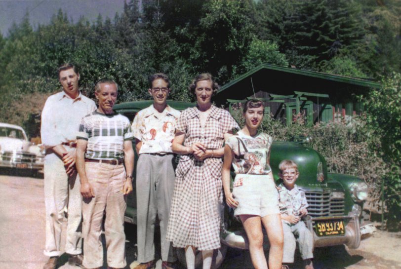Our family poses for our first ever color photo in July 1951. We're joined by my godmother's son Alfred at the far left; his father is taking the picture and it's their green 1941 Cadillac on whose bumper I'm perched. Another thing that's not ours is the house; our own just-purchased summer place here in East Guernewood, California is out of range to the right next door. The only bad thing about this photo is that it was shot on Kodacolor; by now the negative, if it even exists, would be totally opaque. All we have is this 3½ x 5-inch print and, like all Kodacolor prints of that period, it's faded and acquired a predominant yellow cast. Over the years I've tinkered with it several times, and this is my latest restoration effort. For reference, my father is 49 here, my brother almost 14, my mother about to turn 43, my sister 17, and I'm a month away from 5. I didn't have to say "cheese" for the camera; summers at our place at the Russian River were just about the happiest days of my life. View full size.
