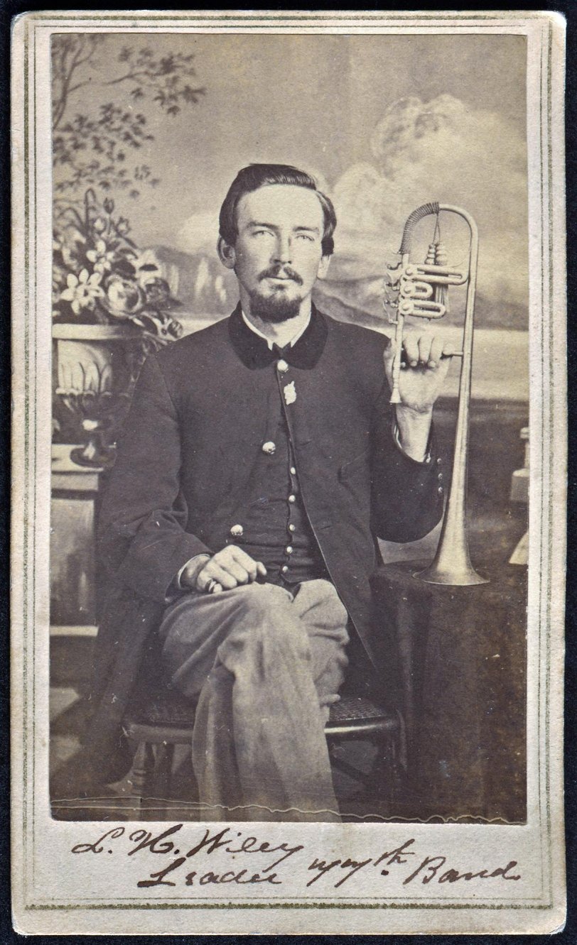 Lemon H. Wiley, band leader and principal musician of the 77th Regiment, Illinois Infantry (M539 ROLL 98), Aug. 15, 1862. He was promoted to Principal Musician June 29, 1864, Elmwood, IL (CdV).
From "Peoria City and County, Illinois: A Record of Settlement, Organization, Progress and Achievement, Volume 2" by James Montgomery Rice, Pub. S. J. Clarke, 1912.
LEMON HILL WILEY
There are many interesting incidents in the life record of Lemon Hill Wiley covering a long experience as a soldier of the Civil war, as a musician in connection with bands and orchestras and later as a political leader, in which connection he has done important public service. He was born in Carmichaels, Greene County, Pennsylvania, April 17, 1844. His father, also a native of that place, was a blacksmith and wagon maker by trade. In early life he was elected justice of the peace and thereafter to the end of his days at each regular election was the candidate of both the Whig and democratic parties. He became widely known as Squire Wiley and his record, uniformly characterized by justice and equity, won him the high commendation of the public. He died in 1882 and in the same decade his wife, who bore the maiden name of -May Jackson, passed away. She was bom in Greene County, near Carmichaels, Pennsylvania, and their children were Jackson, William, Lemon H., Elizabeth, Margaret, Mardelia and two who died in infancy.
Lemon H. Wiley attended the country schools, in which he acquainted himself with the usual branches of learning that constituted the public-school curriculum. He was too much of a musician, however, to make a good blacksmith, although he entered his father’s shop and attempted to learn the trade. He would whistle while he was pounding the hot iron and the nails which he was attempting to draw, for so the process was termed, would grow cold. At length his father said: “You are no blacksmith. I will make of you a musician." Nothing could have better suited the lad and for years his developing musical talent kept him in a foremost position among musical leaders of this and other states ...
